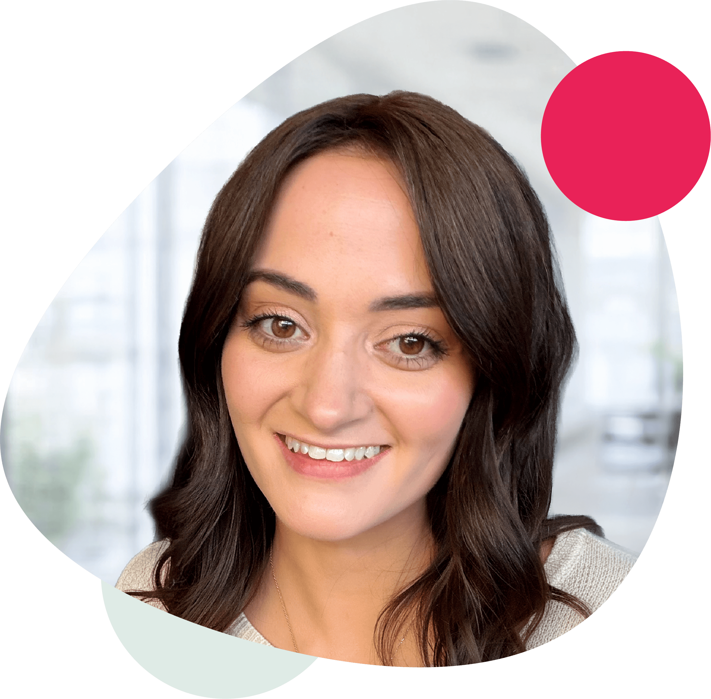 Smiling woman with long ombre hair, framed by an organic rounded triangle shape with pink and green accents, indoors with natural light