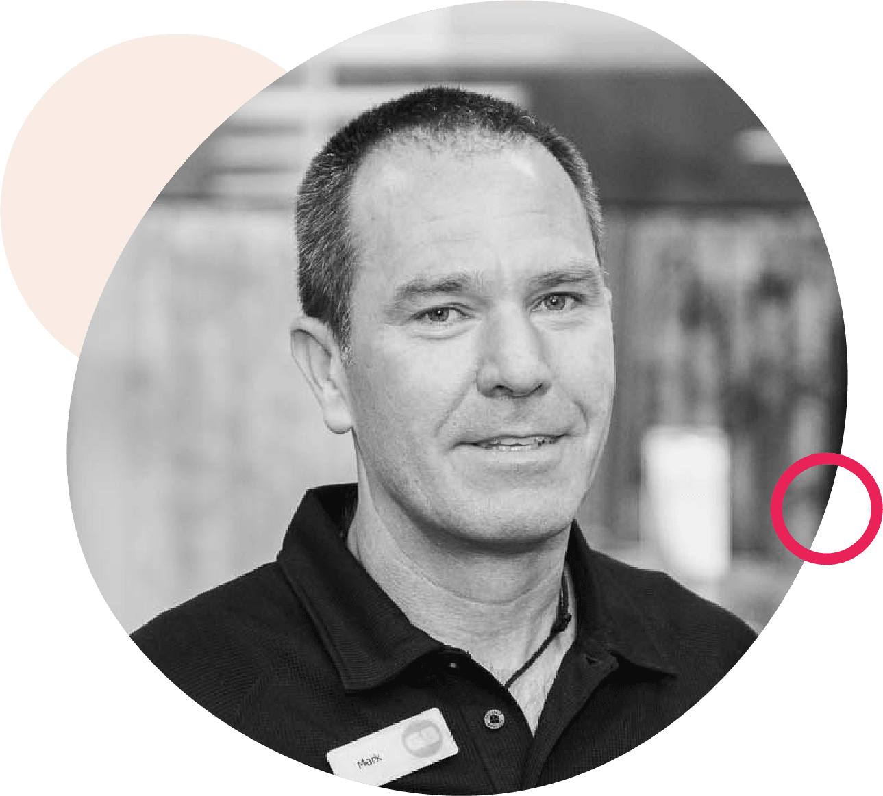 Black and white portrait of a man in a black polo shirt with a name badge, framed by abstract beige and pink shapes