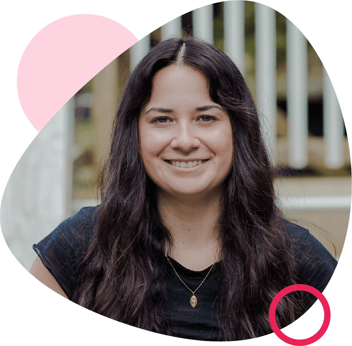 Smiling woman with long dark hair in a black top, framed by a rounded shape with pink accents, standing outdoors near a white railing