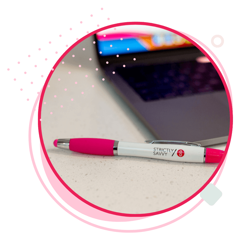 Desktop computer on a modern desk with "Get Savvy" displayed on the screen, surrounded by vibrant graphic shapes