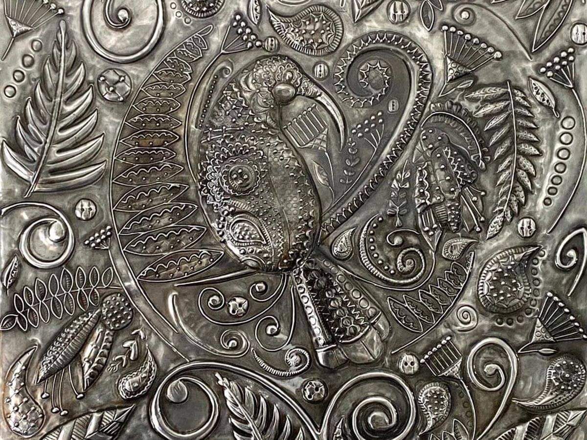 Detail of the huia and lace patterns hand-embossed in pewter on Huia's Lustrous Lacework