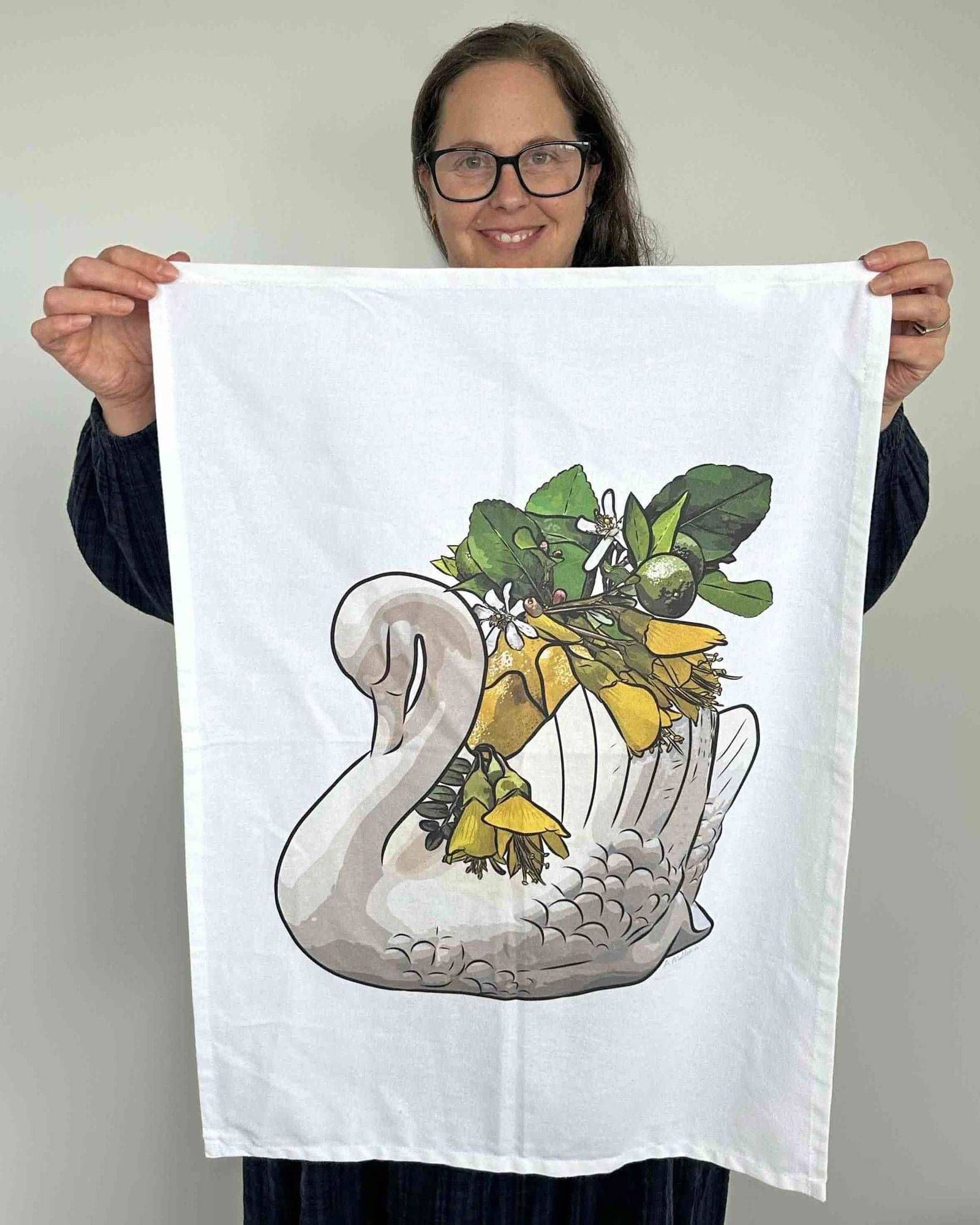 Anna Mollekin holding her Lemon Honey Crown Lynn swan tea towel