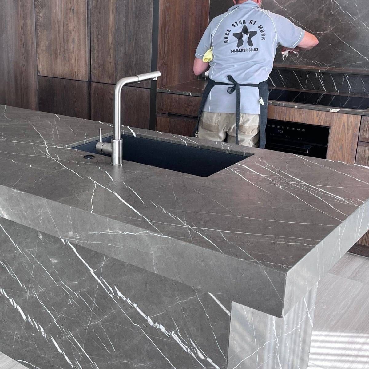 Dark marble kitchen benchtop after restoration and sealing in Auckland.