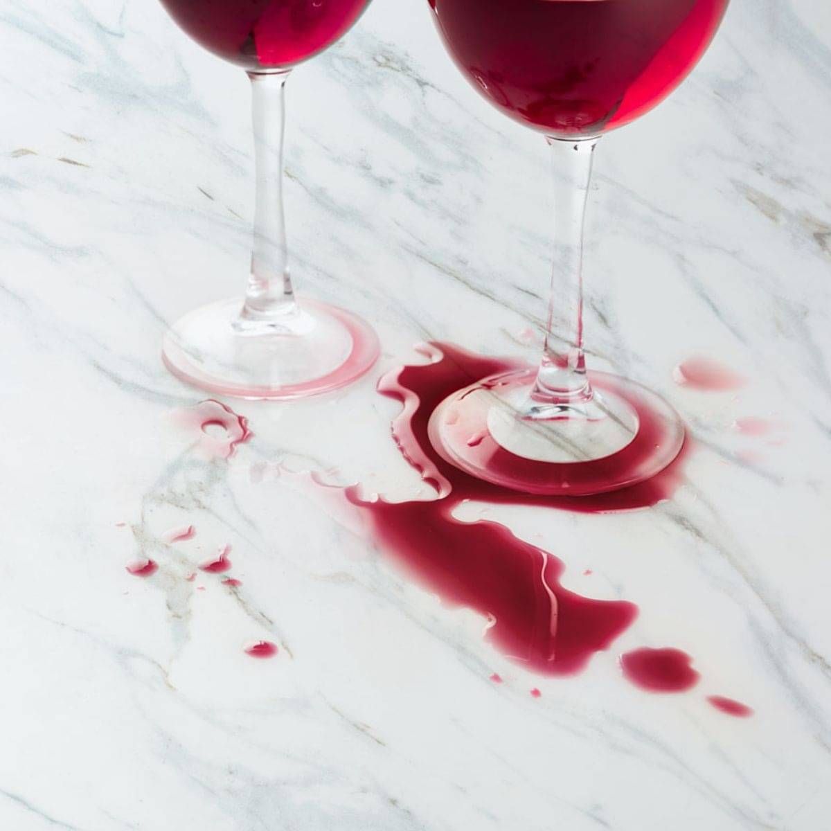 Red wine spill on white marble showing common staining and etching risk.