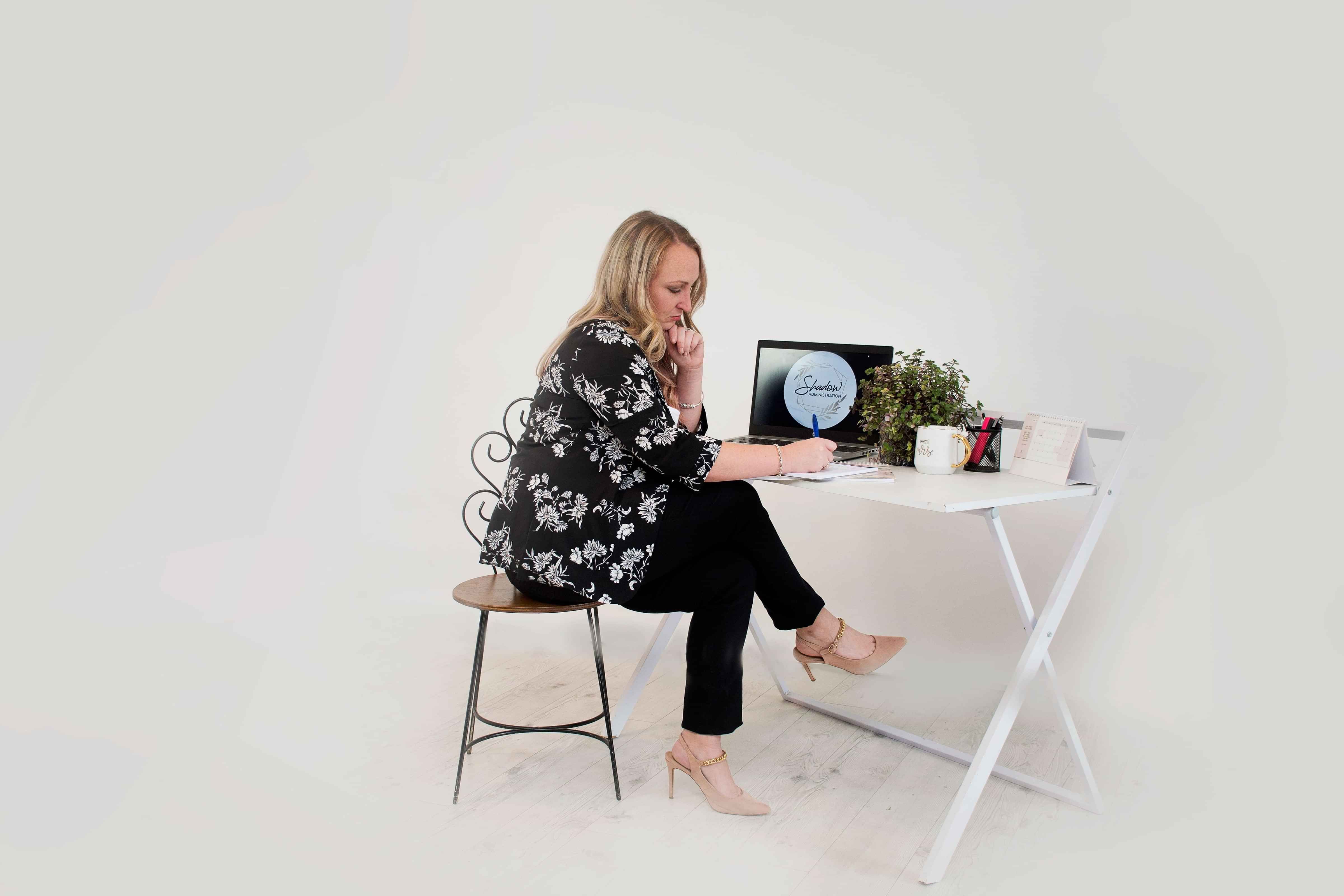 Toyah, Virtual Office Manager at desk writing on a notebook.