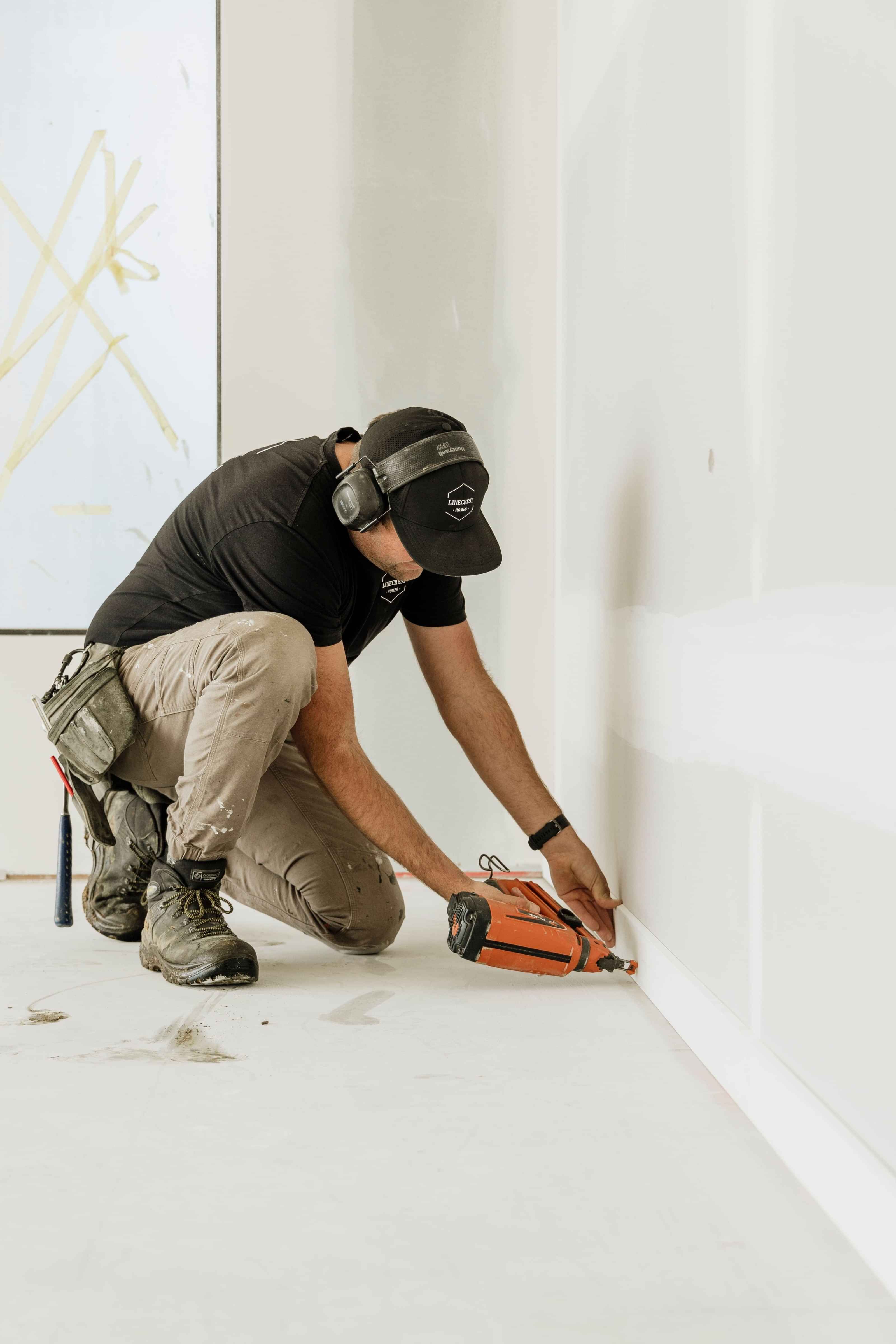 Down low a member of the Linecrest team secures skirting boards on this new house build.