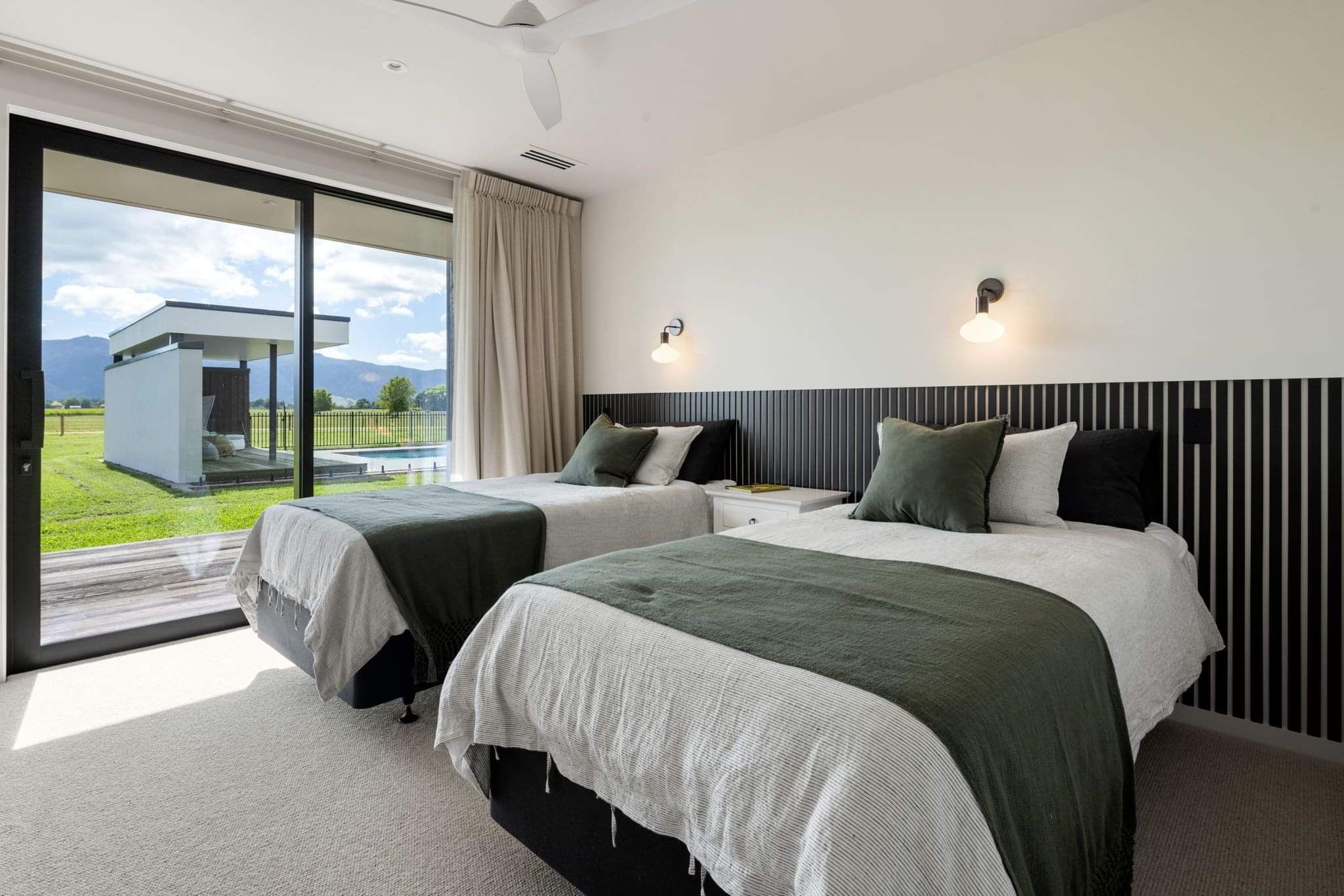 Enjoy rural views from this light-filled double bedroom with full sliding glass doors, built by Linecrest Homes.