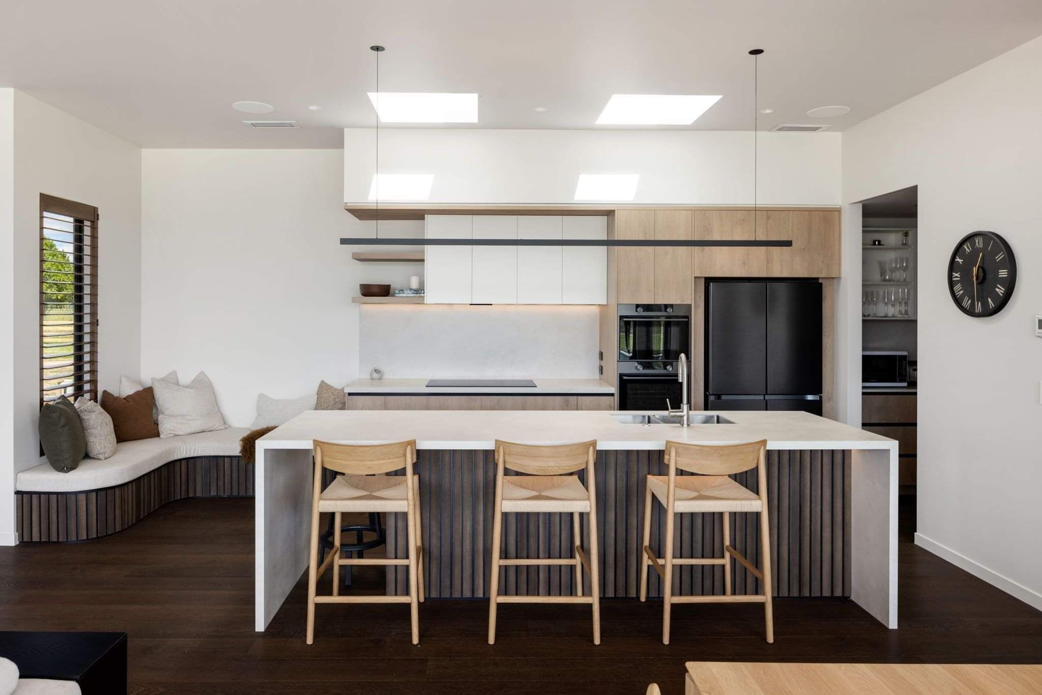This modern kitchen features white and natural wood tones, making it a light and open design ready to entertain.