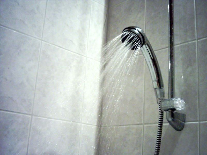 A shower head, water flowing and a link to Sensor Shower and other Enviro-Tech products