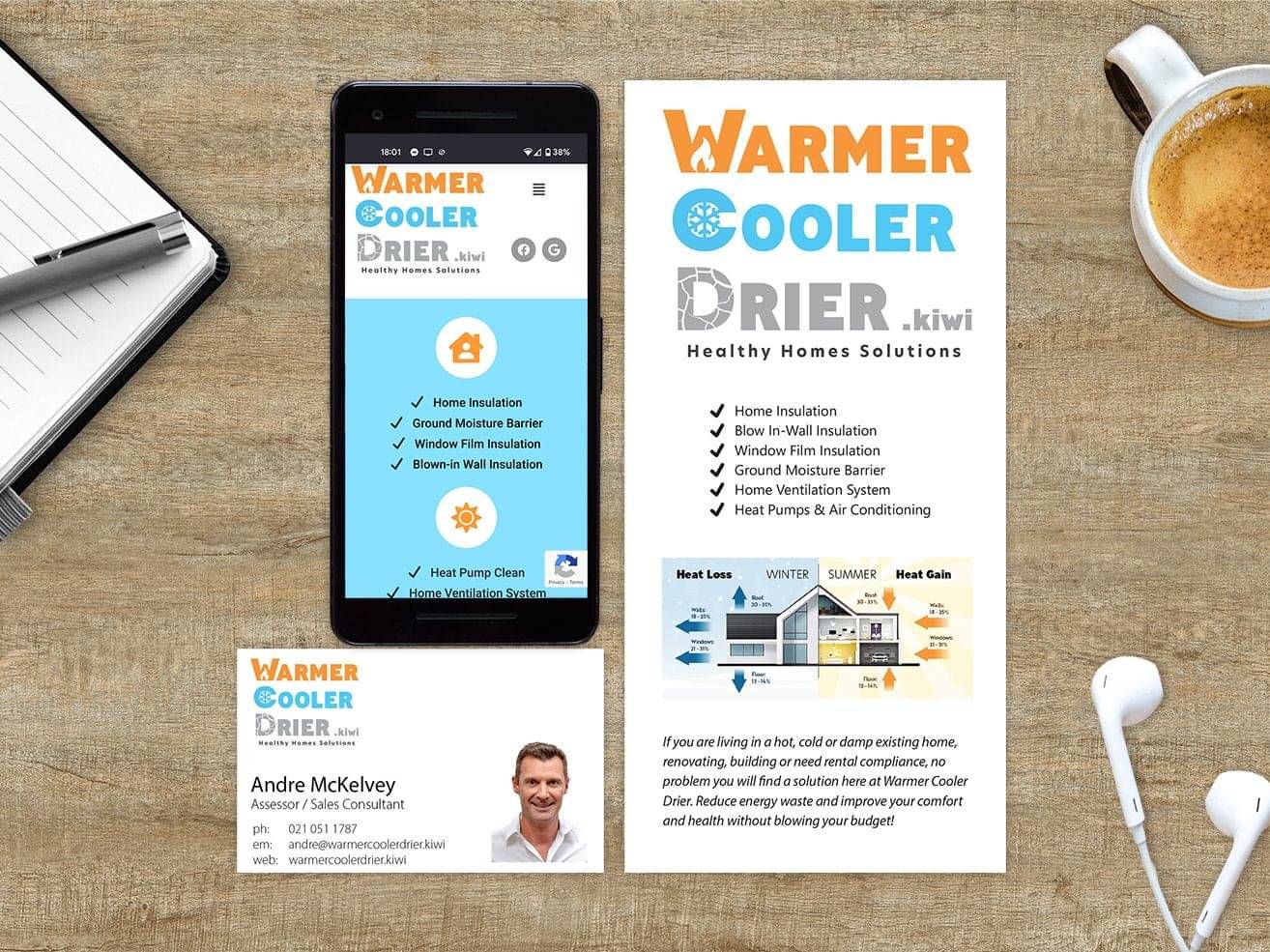 A flyer, business card, and website on a phone, all laid out on a desk