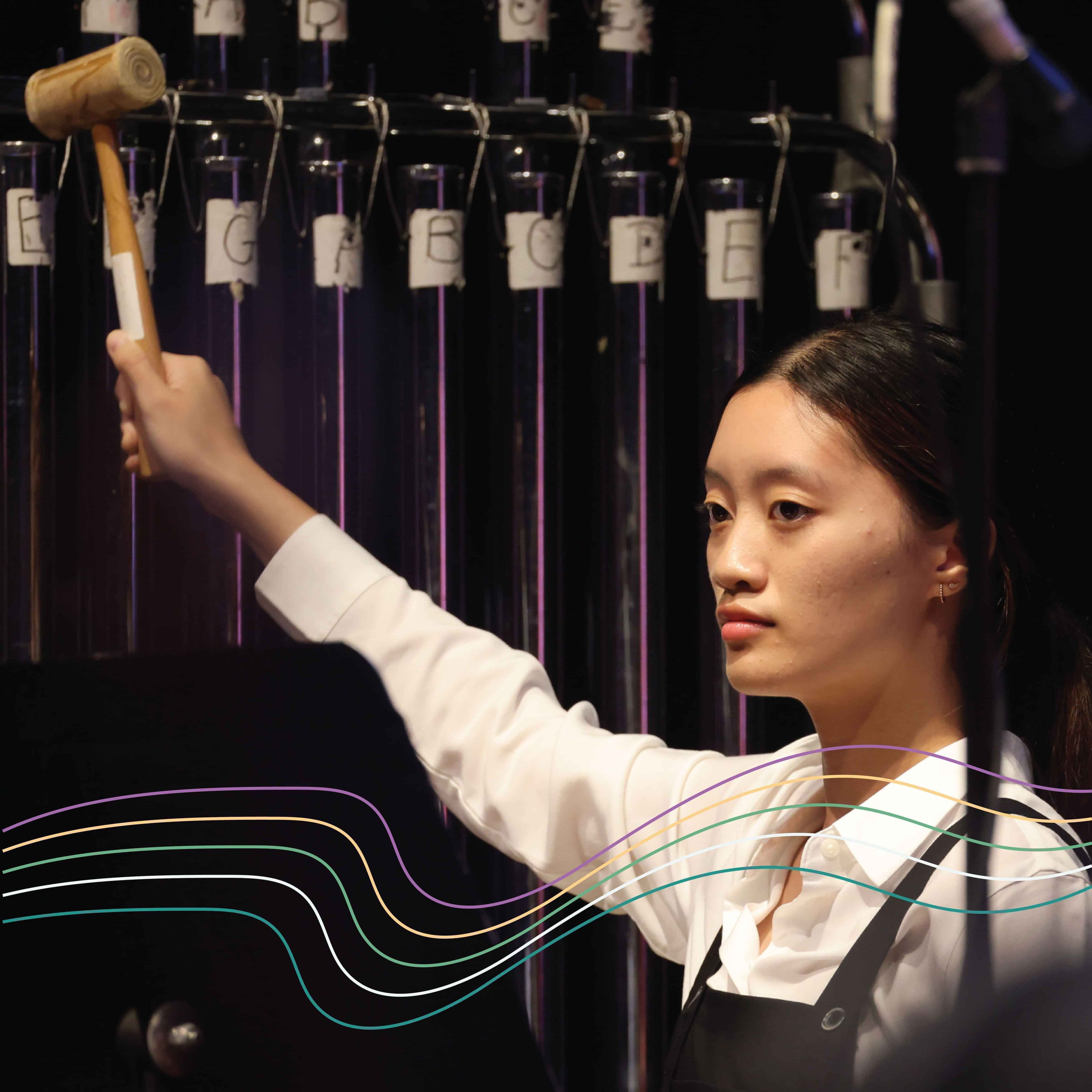 Girl from youth orchestra playing tubular bells