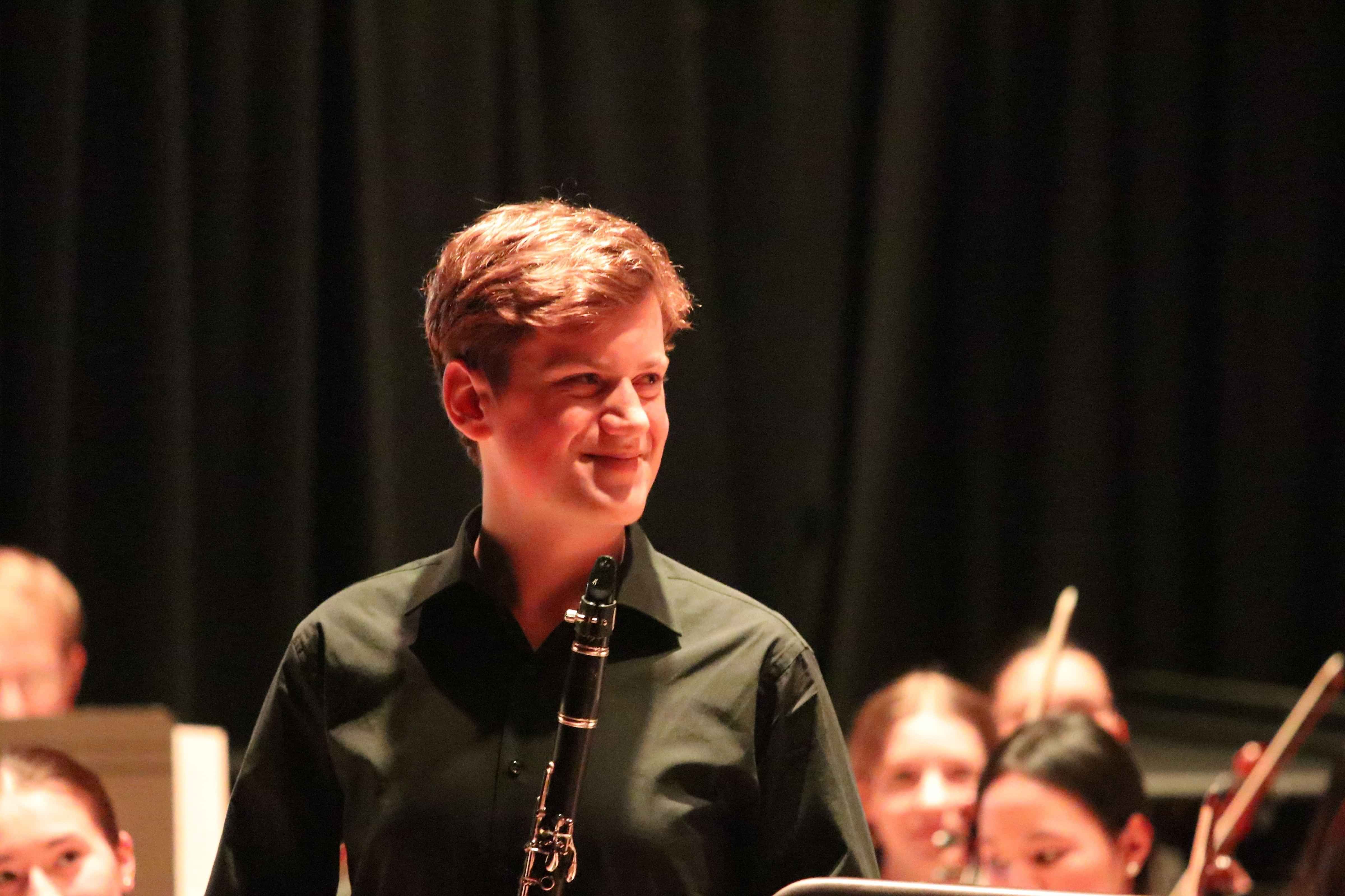 Matthew smiling and holding clarinet