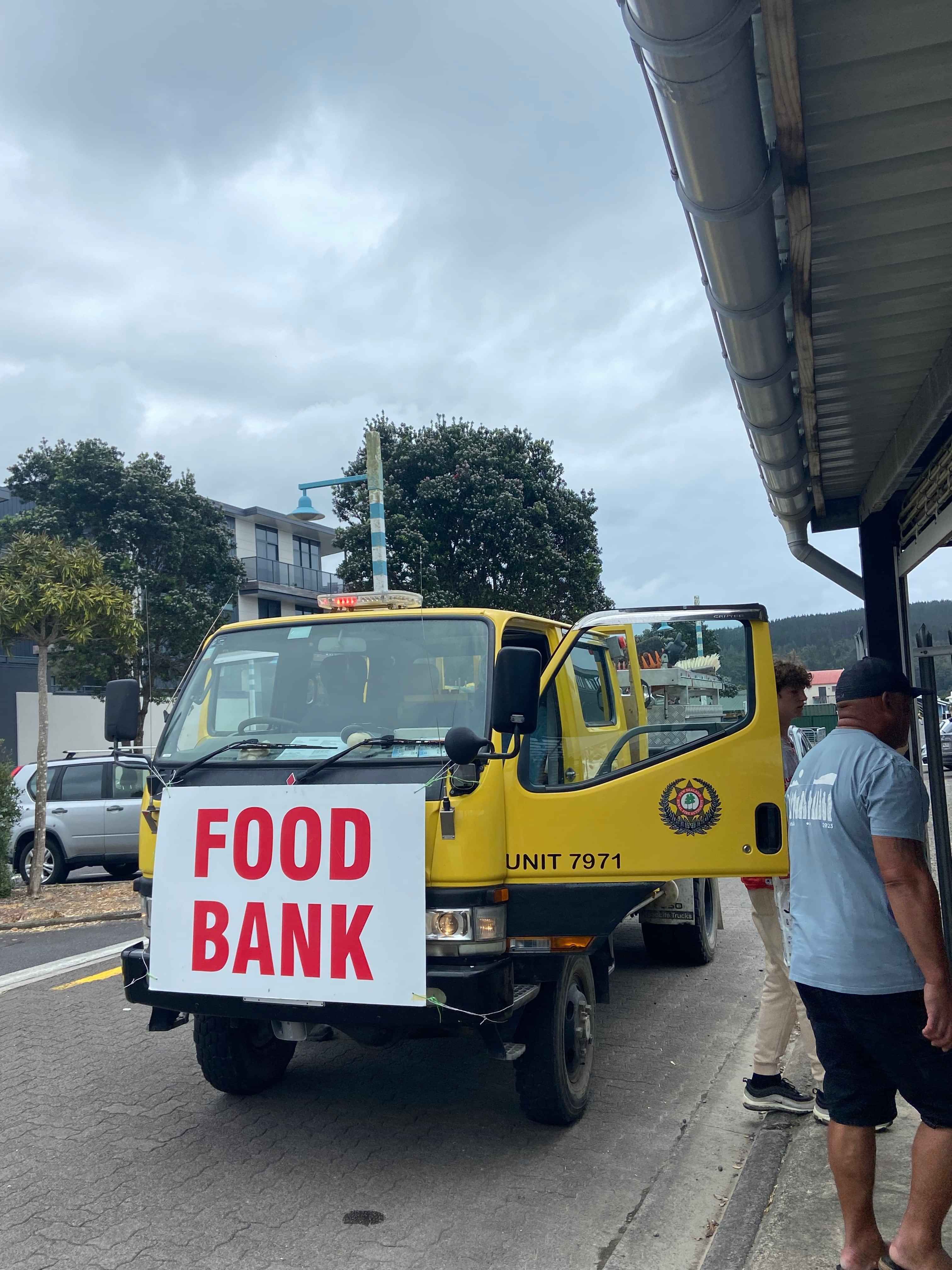 Image of a yellow truck with a large food bank sign on the front