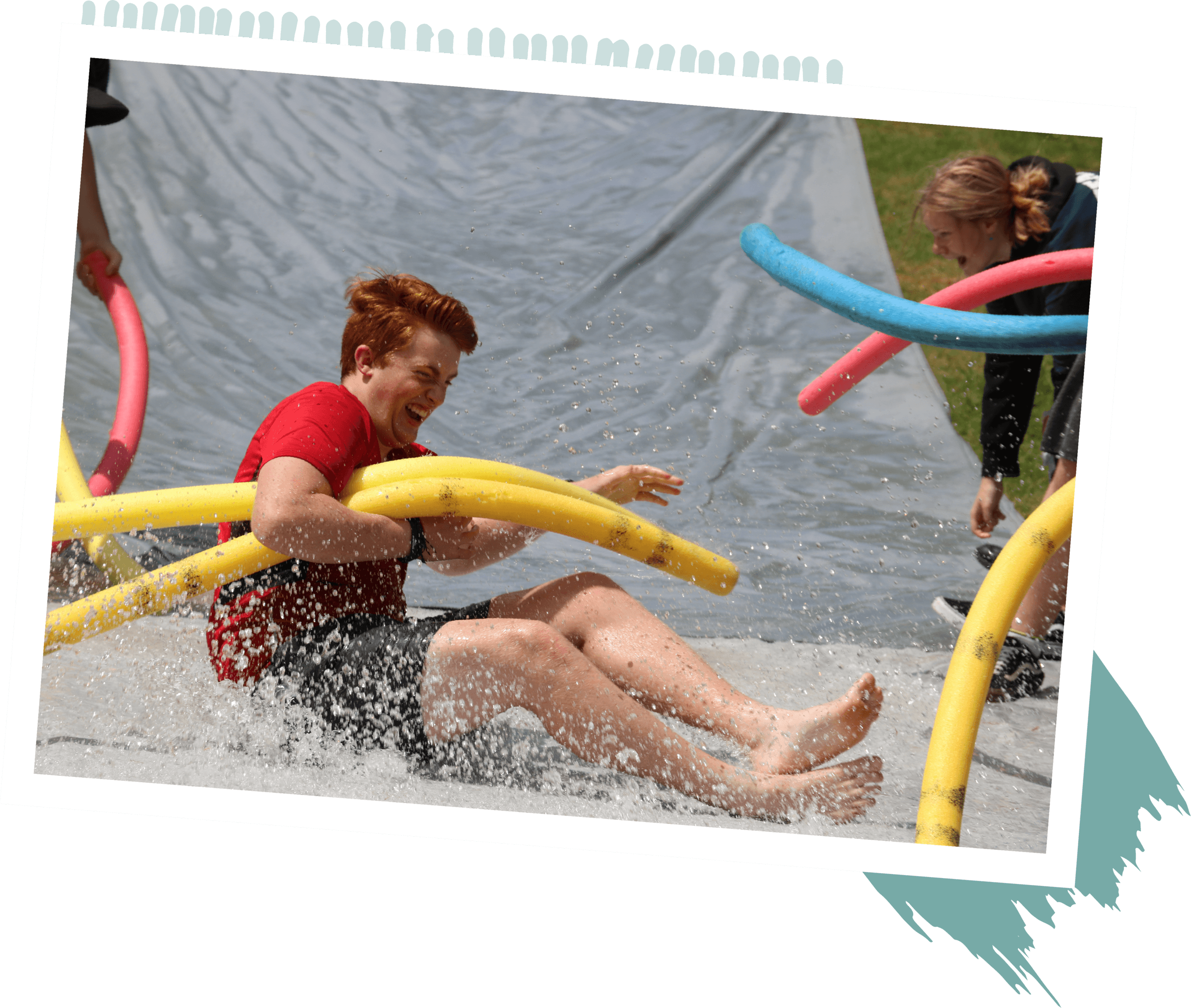 Boy on water slide with pool noodle