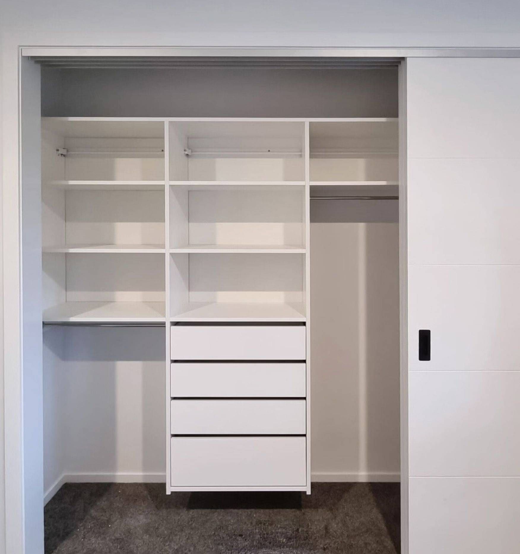 White shelving in a customised bedroom cupboard.