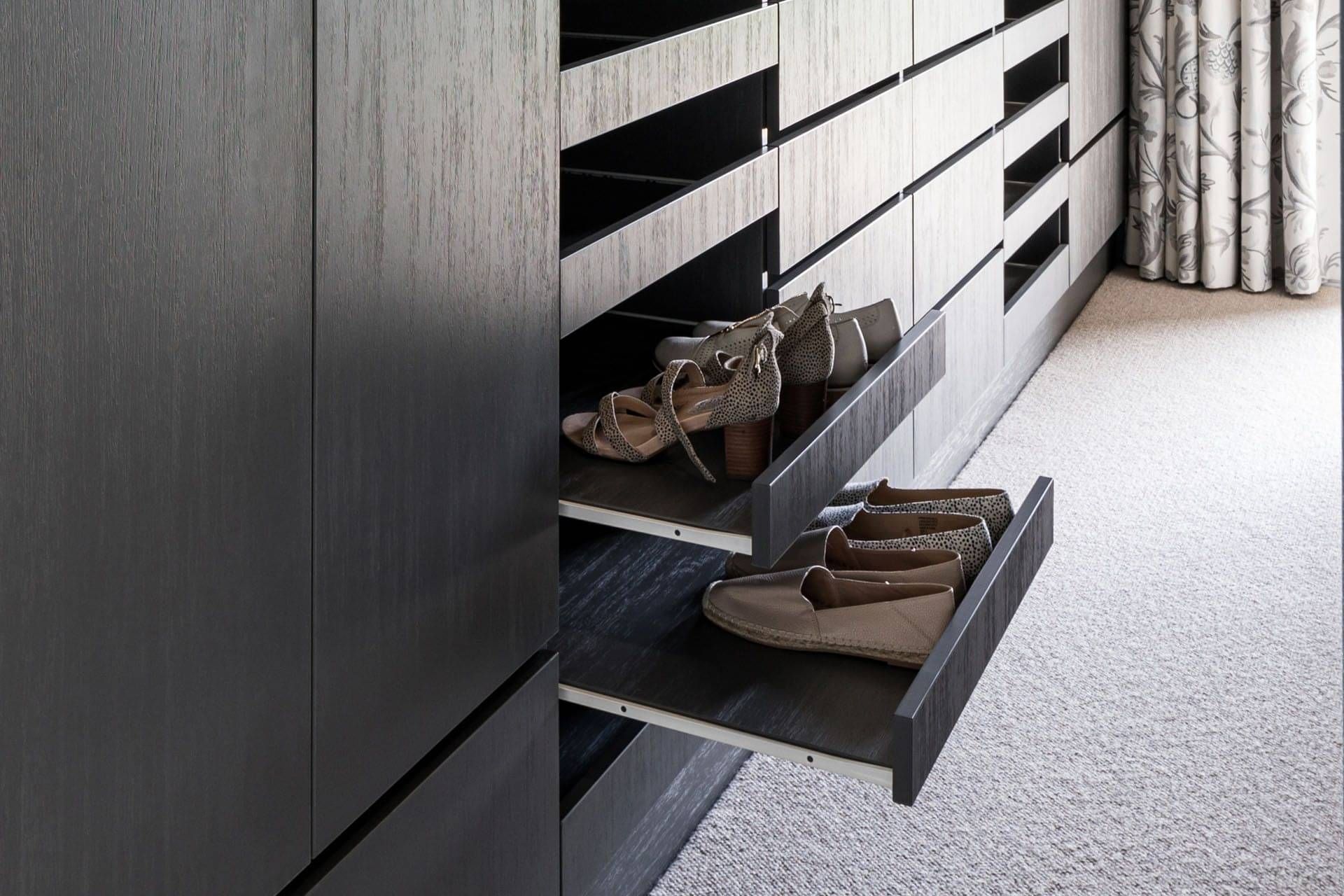 Pull-out shelving showing storage of shoes.