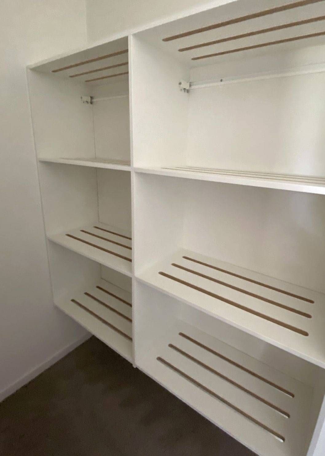 Built-in shelving with white slatted shelves.