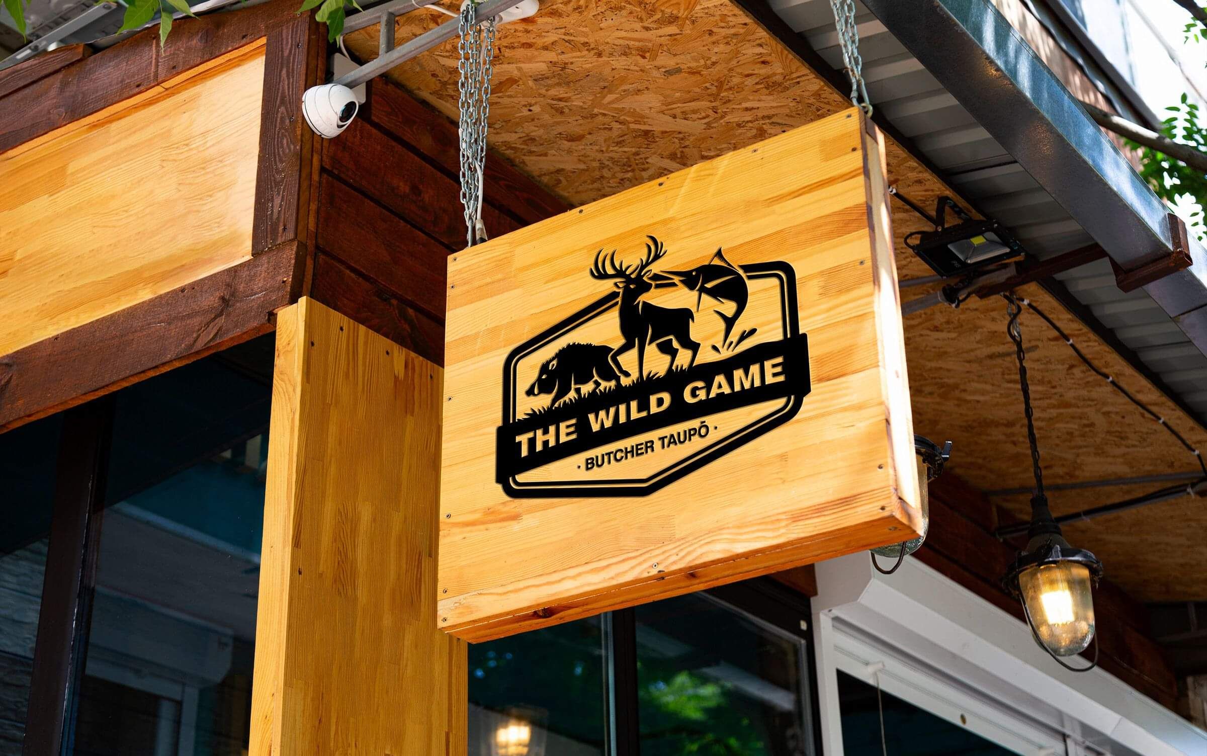 Wild Game Butcher Logo on a wooden sign hanging above their shop