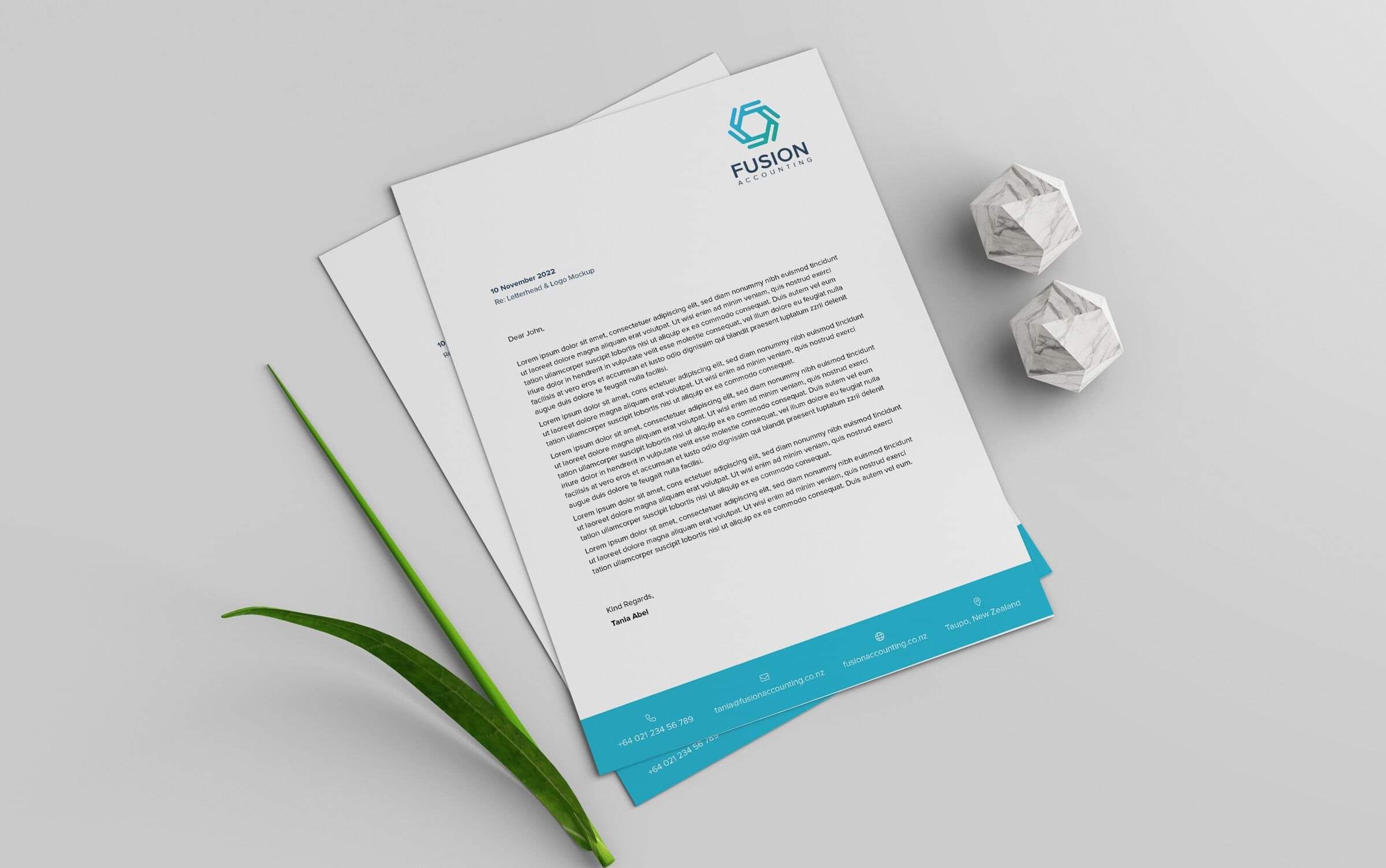 Fusion Accounting Letterhead design, laid on a table with a twig and 2 paper weights