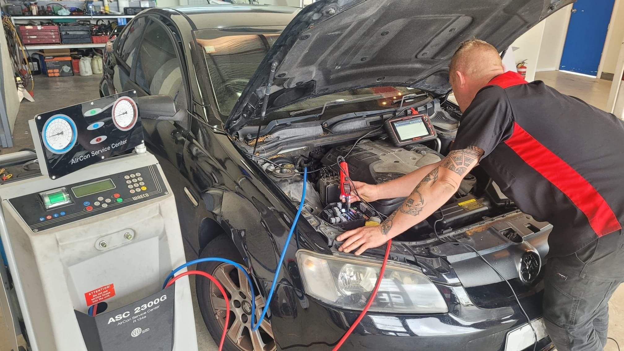 Technician carrying out de-gas with Waeco refrigerant machine whilst checking for electrical issues.