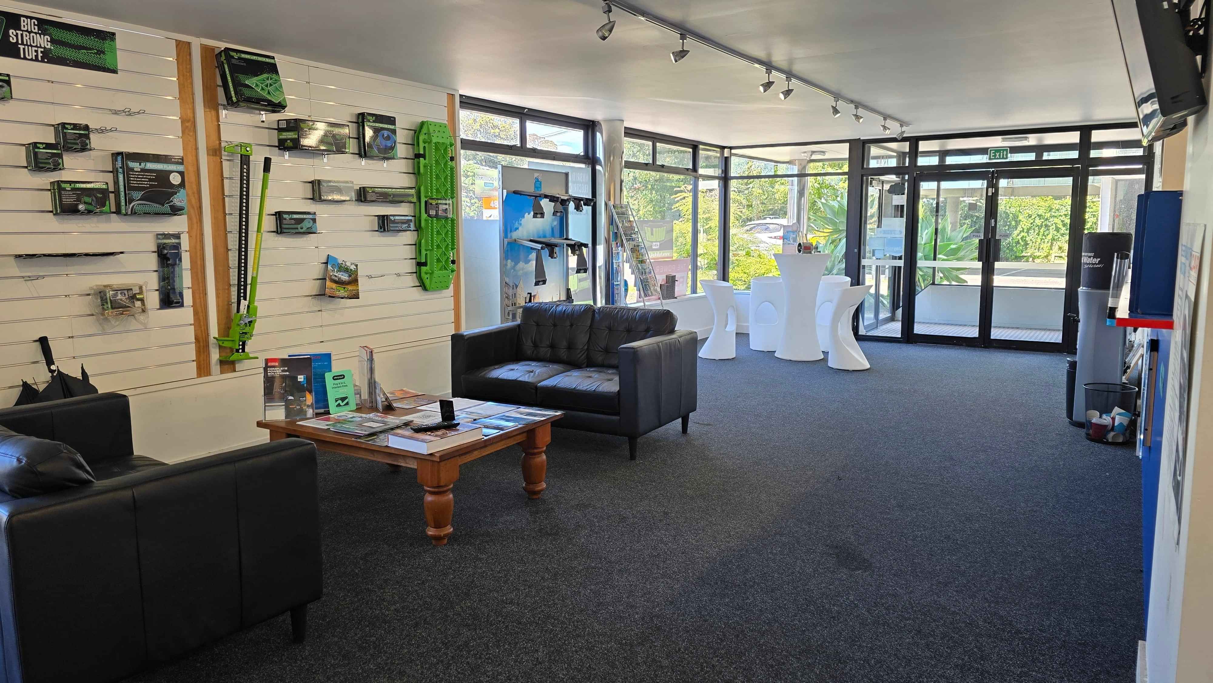 Waiting room area of CoolCar North Shore Office, with lounge suite and HULK 4X4 display rack