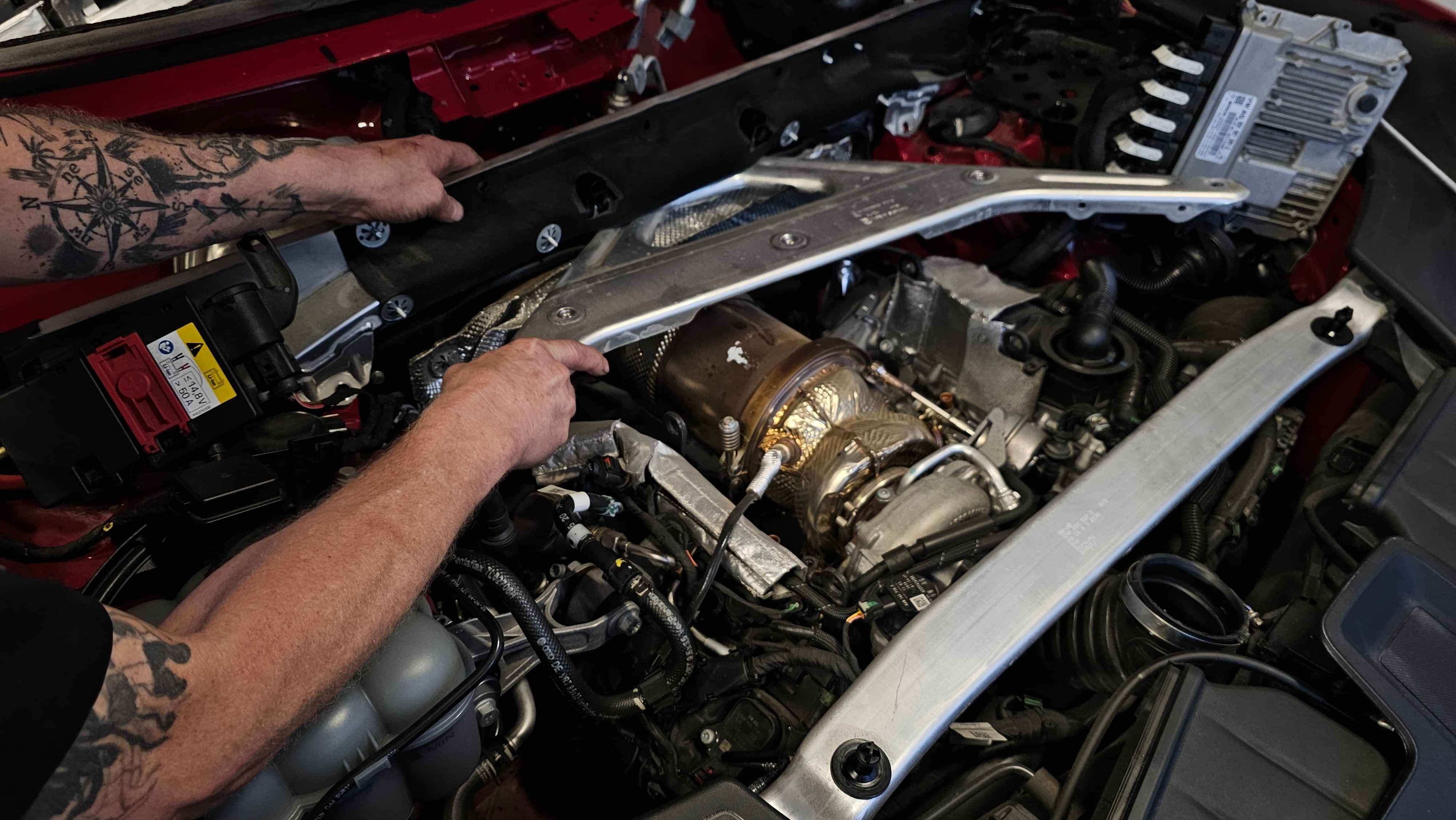 Taking off engine cover for better firewall access at CoolCar Henderson