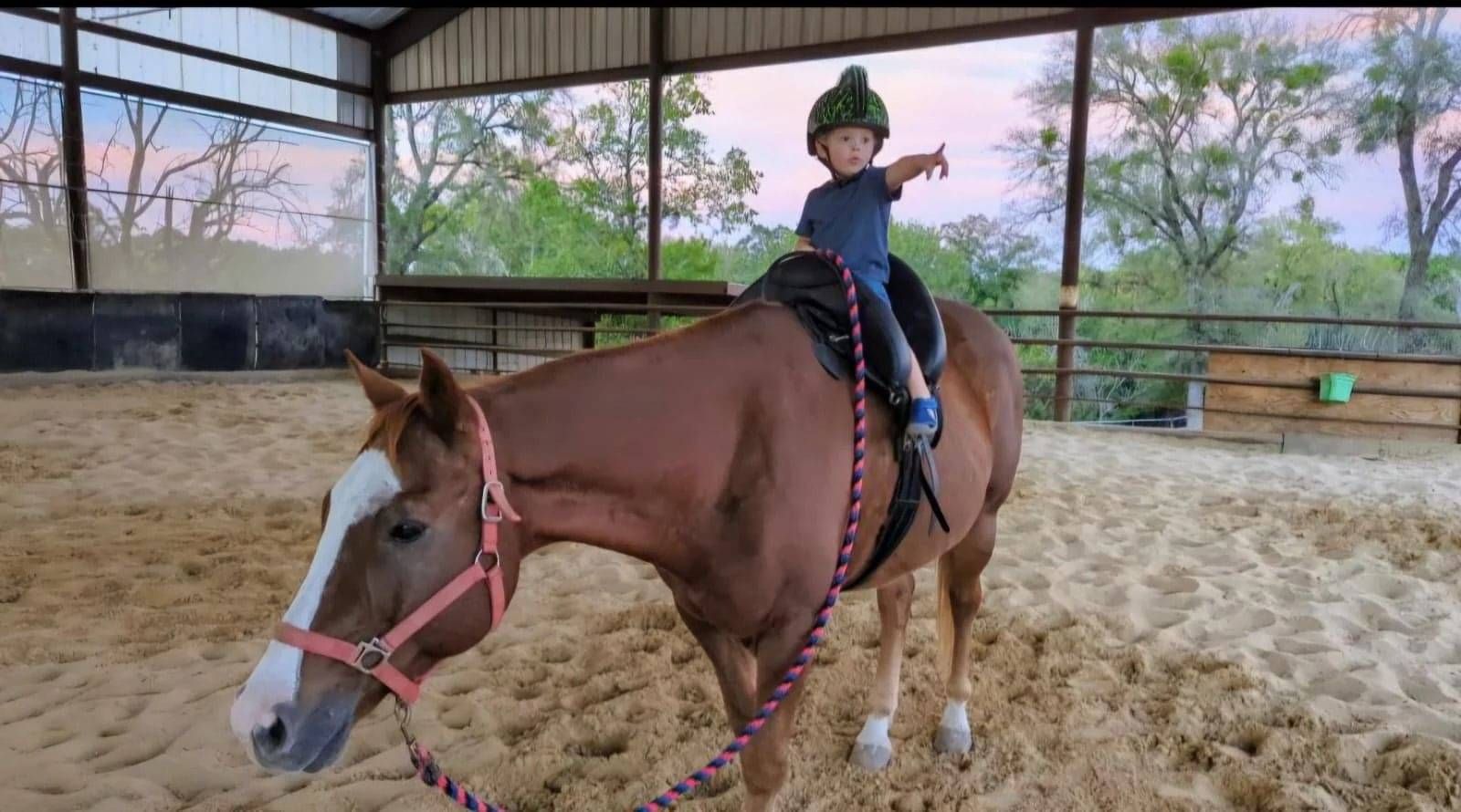 Young rider smiling while seated in an Inky Dinky Saddle