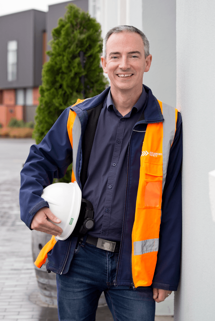 Matt Jones in Advanced Safety high visibility gear holding a hard hat