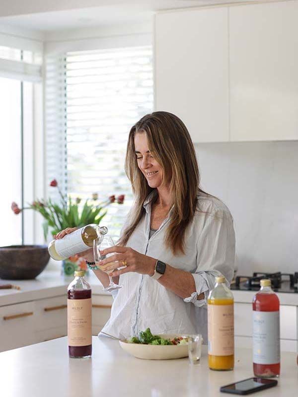 Professional photoshoot of woman making drink in kitchen in Matakana