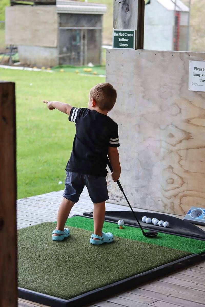 Photo of young boy playing golf