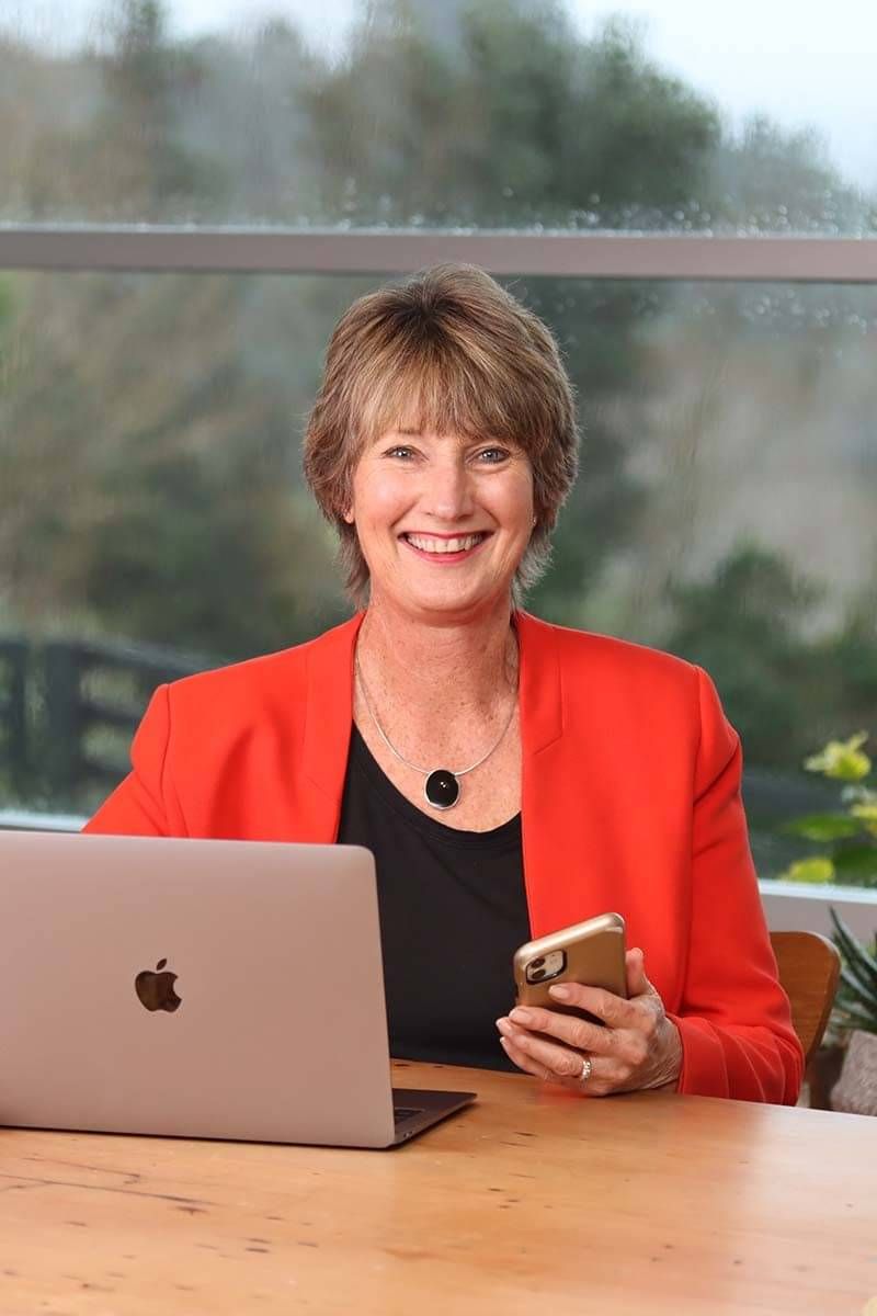 Corporate headshot of woman in orange blazer