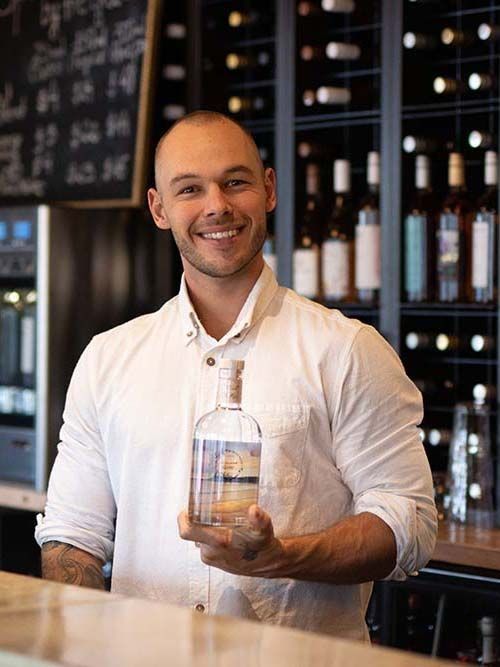Business headshot of bartender holding Matakana Gin bottle