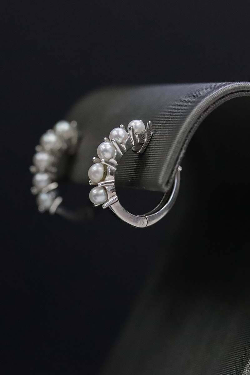 Product image of pearl earrings on black background