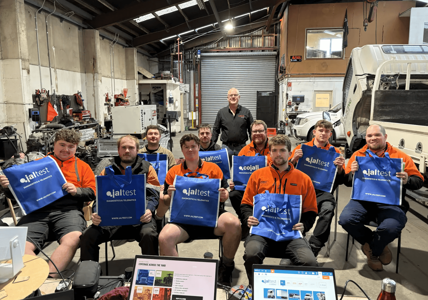 AECS Equipment team holding Jaltest diagnostics bags at a training session in the workshop