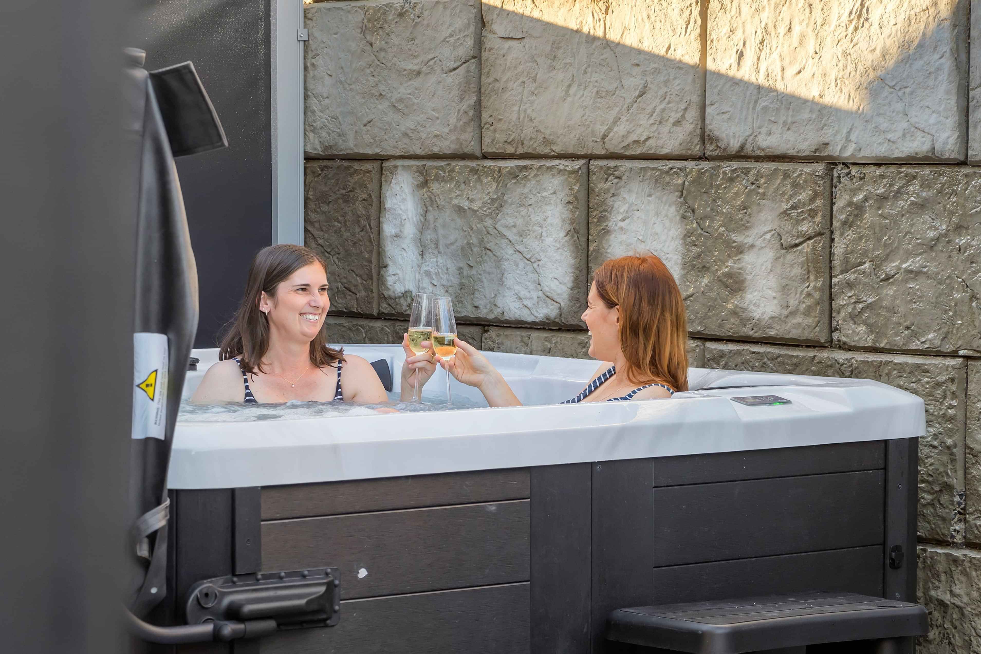 Guests relaxing in the outdoor spa pool at Roam Taupo lakefront accommodation