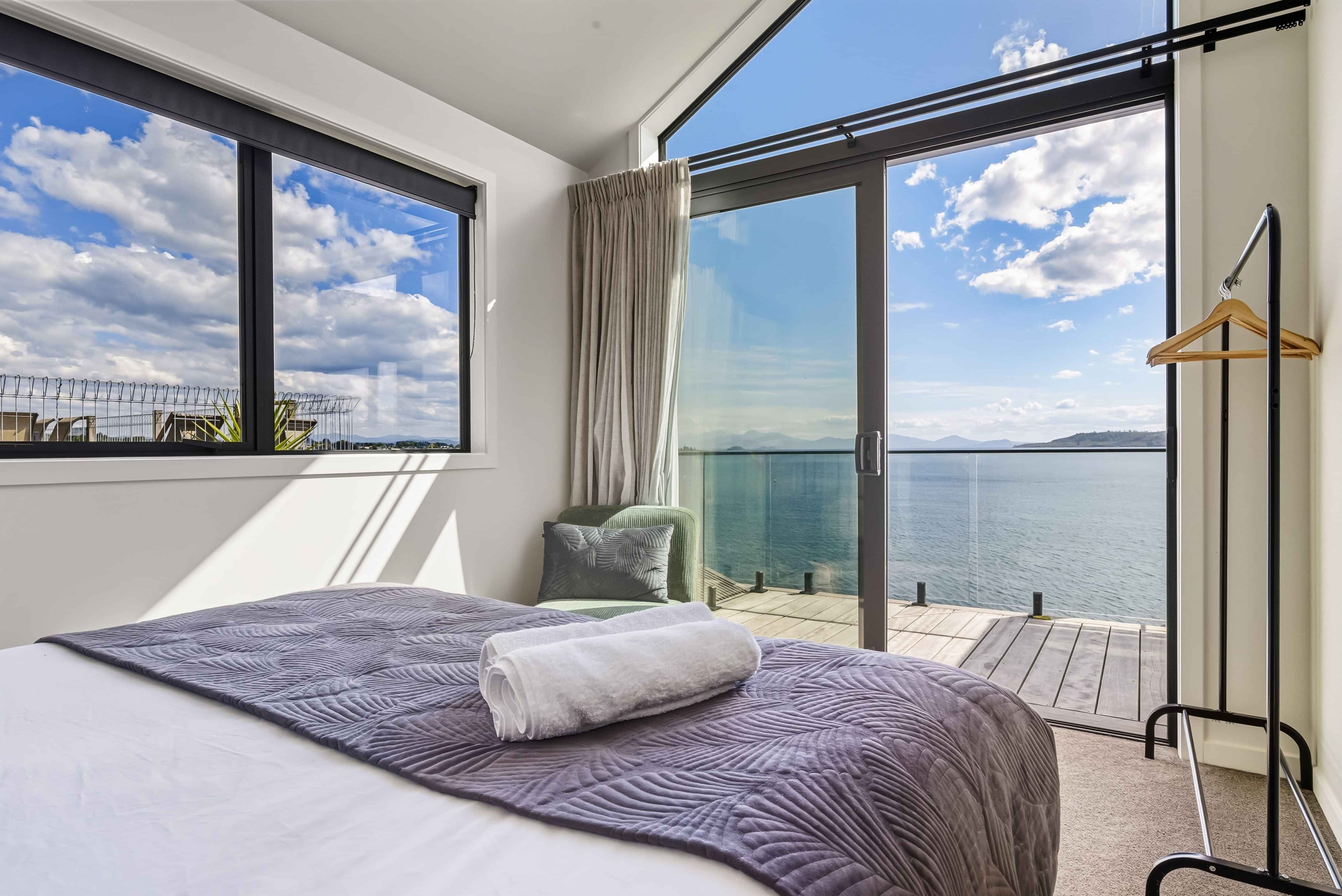 King bed with lake and mountain views in the master bedroom of a Roam Taupo upper terrace unit