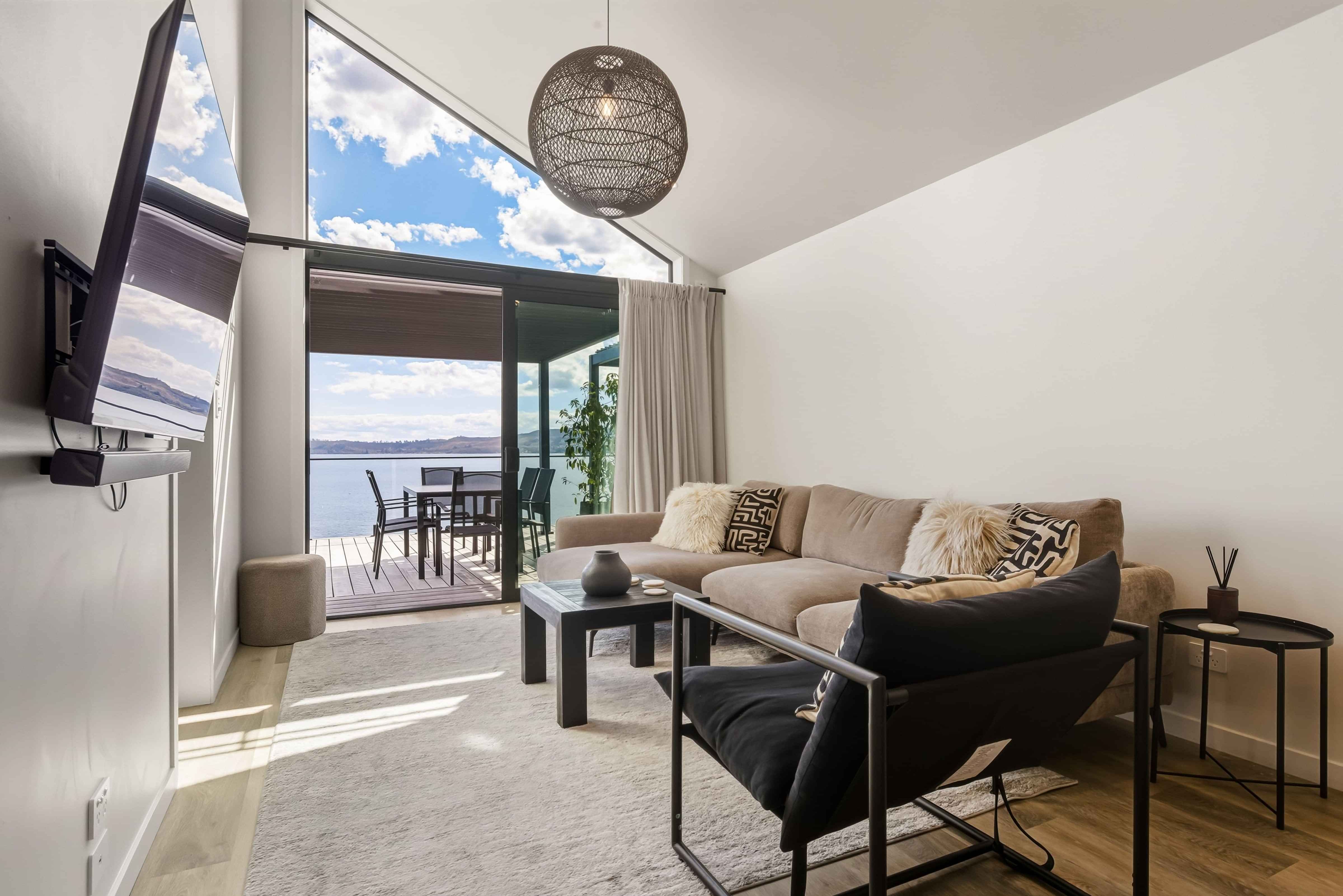Open-plan living and kitchen with lake views at Roam Taupo lakefront accommodation
