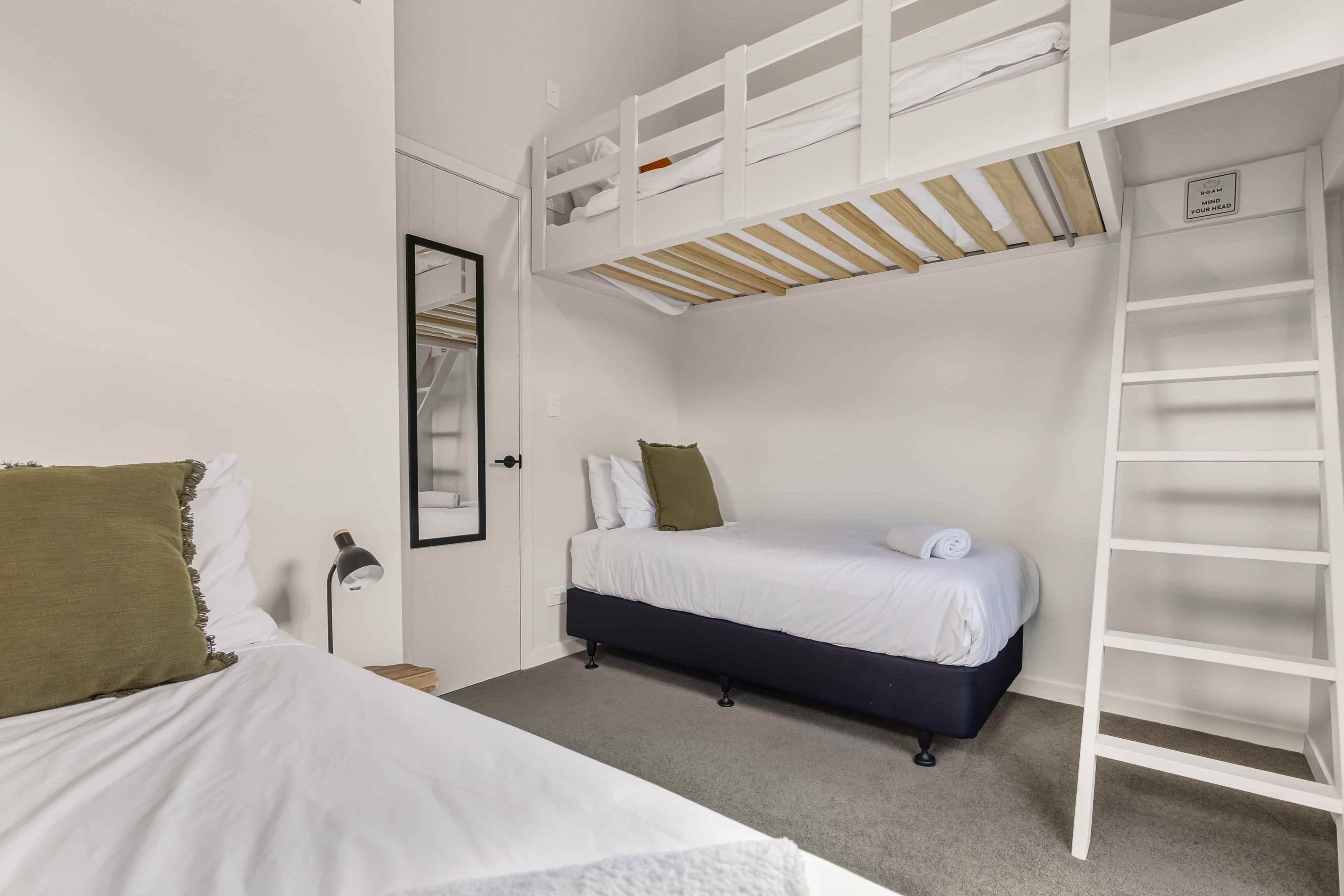 Second bedroom with three single beds including a loft bunk at Roam Taupo lakefront unit