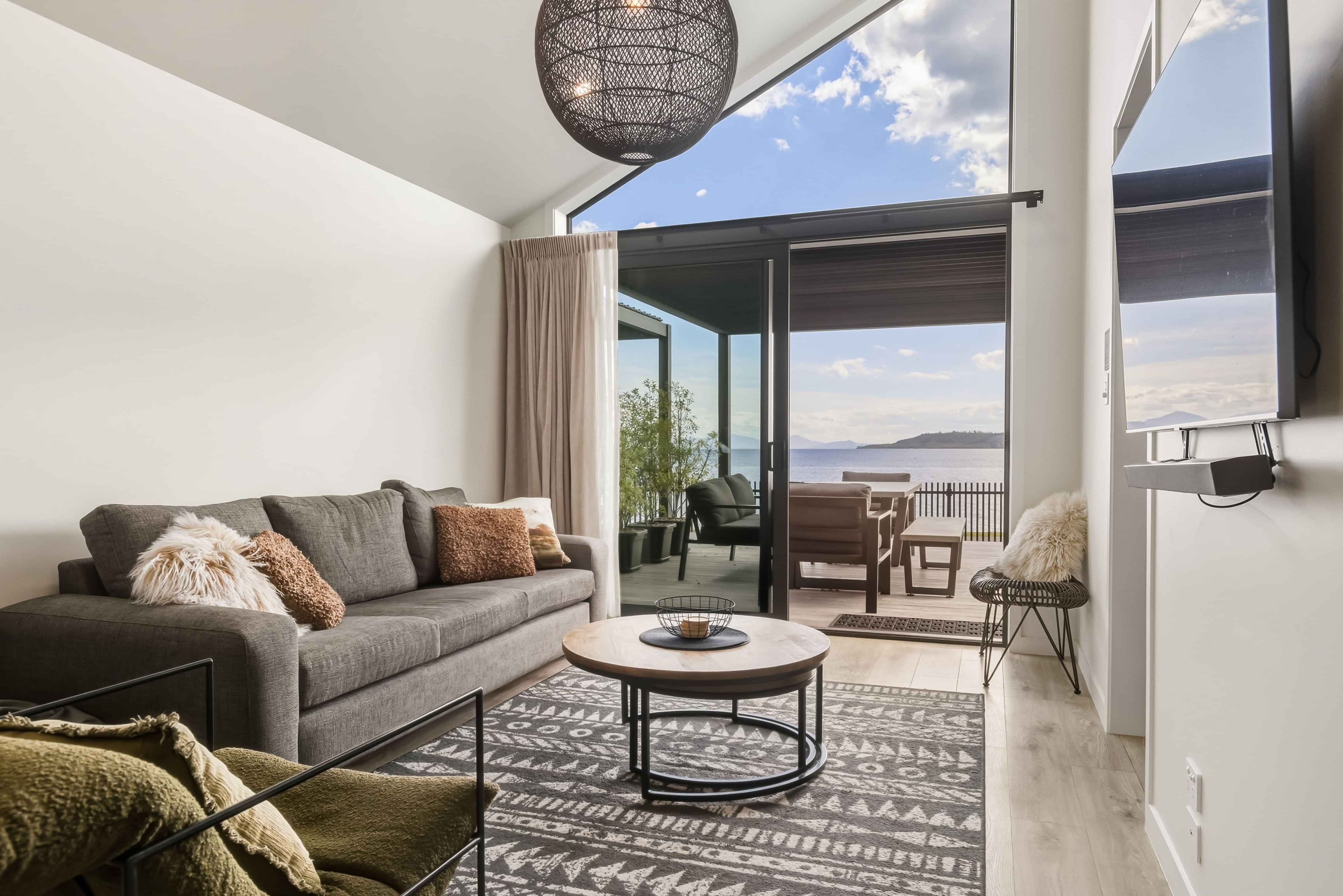 Open-plan living and kitchen with lake views at Roam Taupo lakefront accommodation