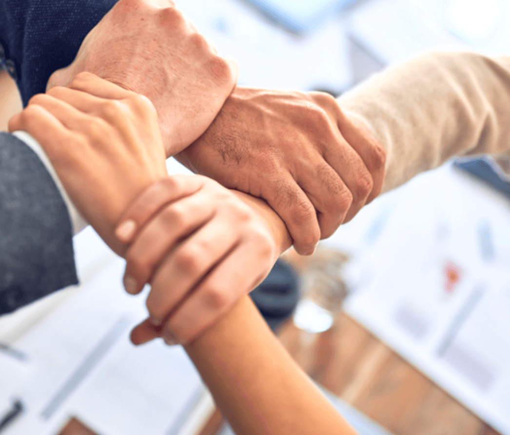 Hands holding each others wrist in sign of support.