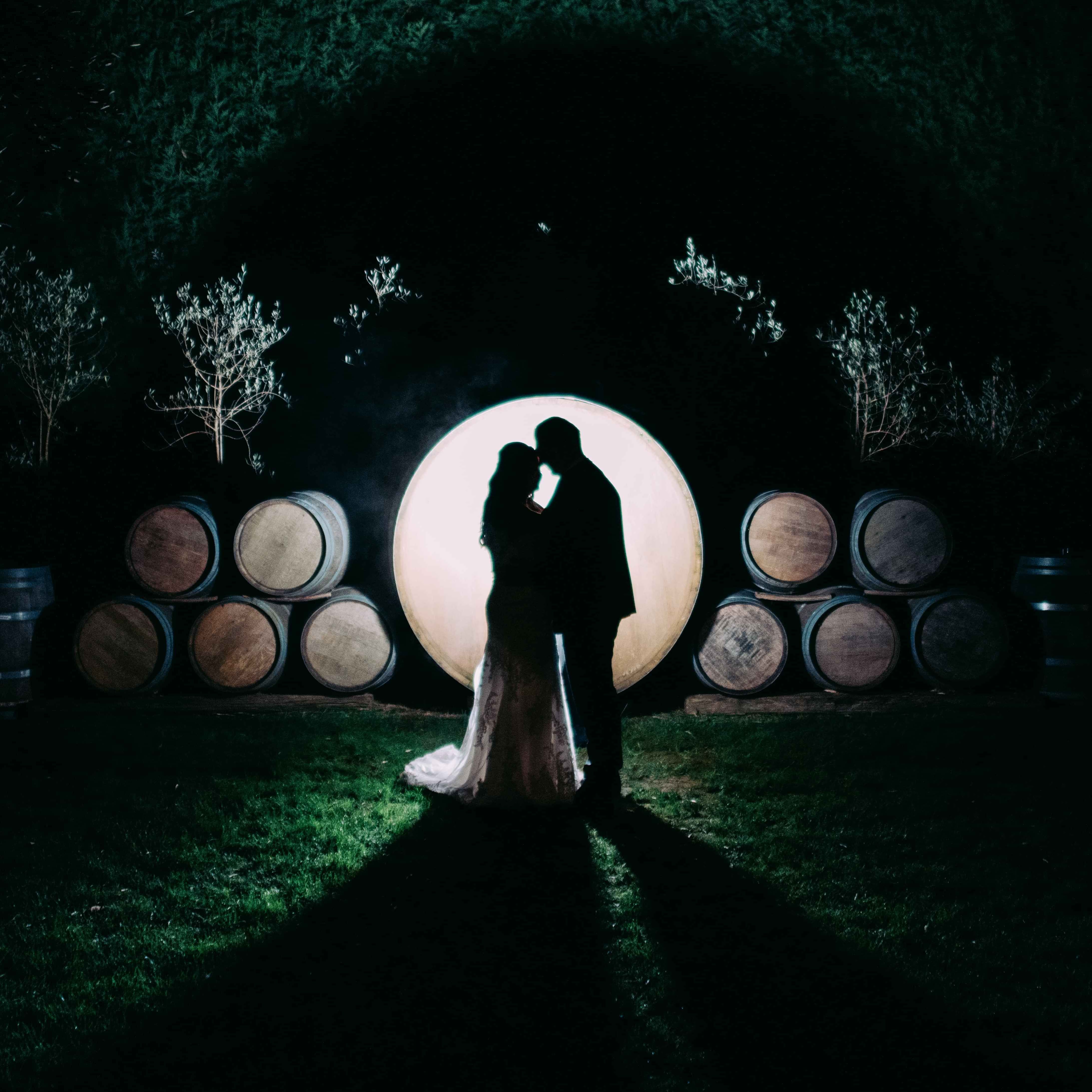 Markovina Vineyard Estate Couple posing in silhouette of barrels 