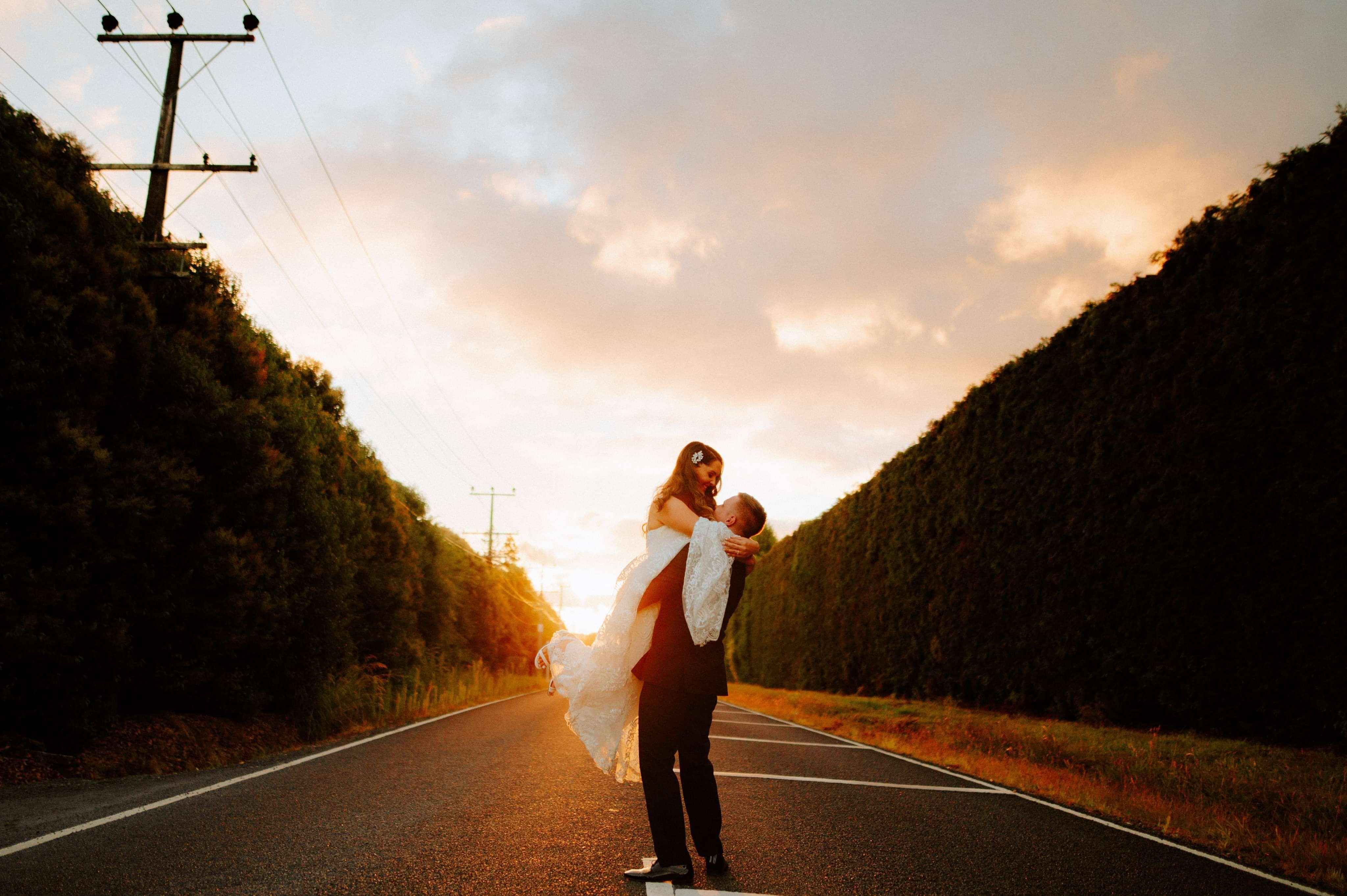 cinematic shot of wedding couple in the middle of the road