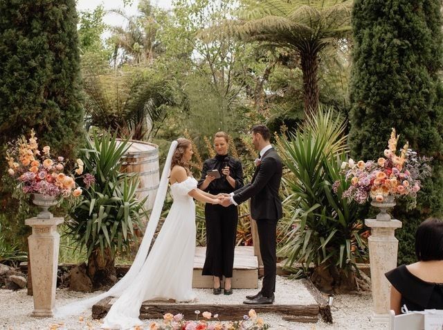 bride and groom posing in front of barrels