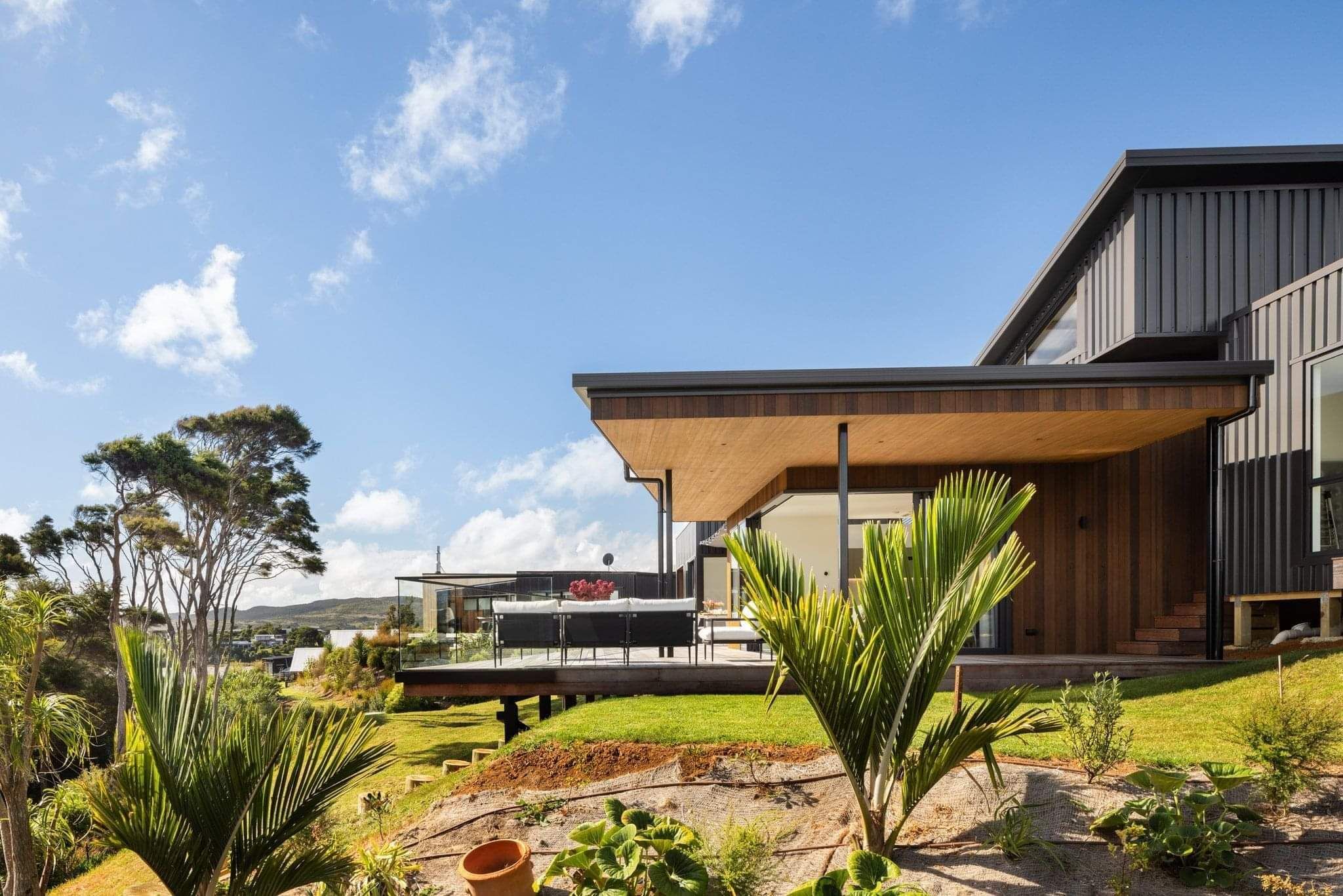 Open‑plan coastal home with stacking slider doors, indoor‑outdoor flow, Nixon Homes