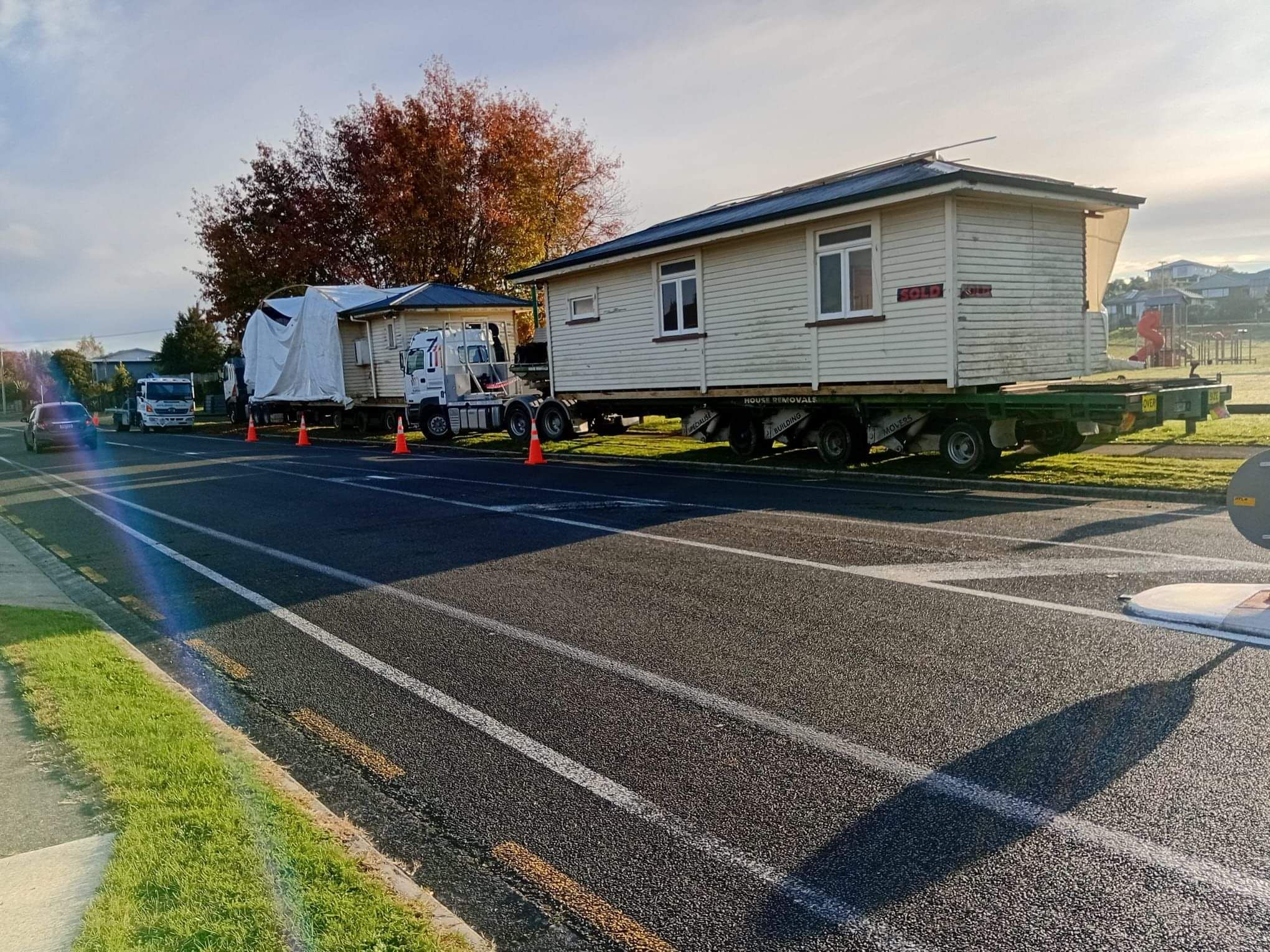 House relocation Waikato: transporting a weatherboard home on two trucks
