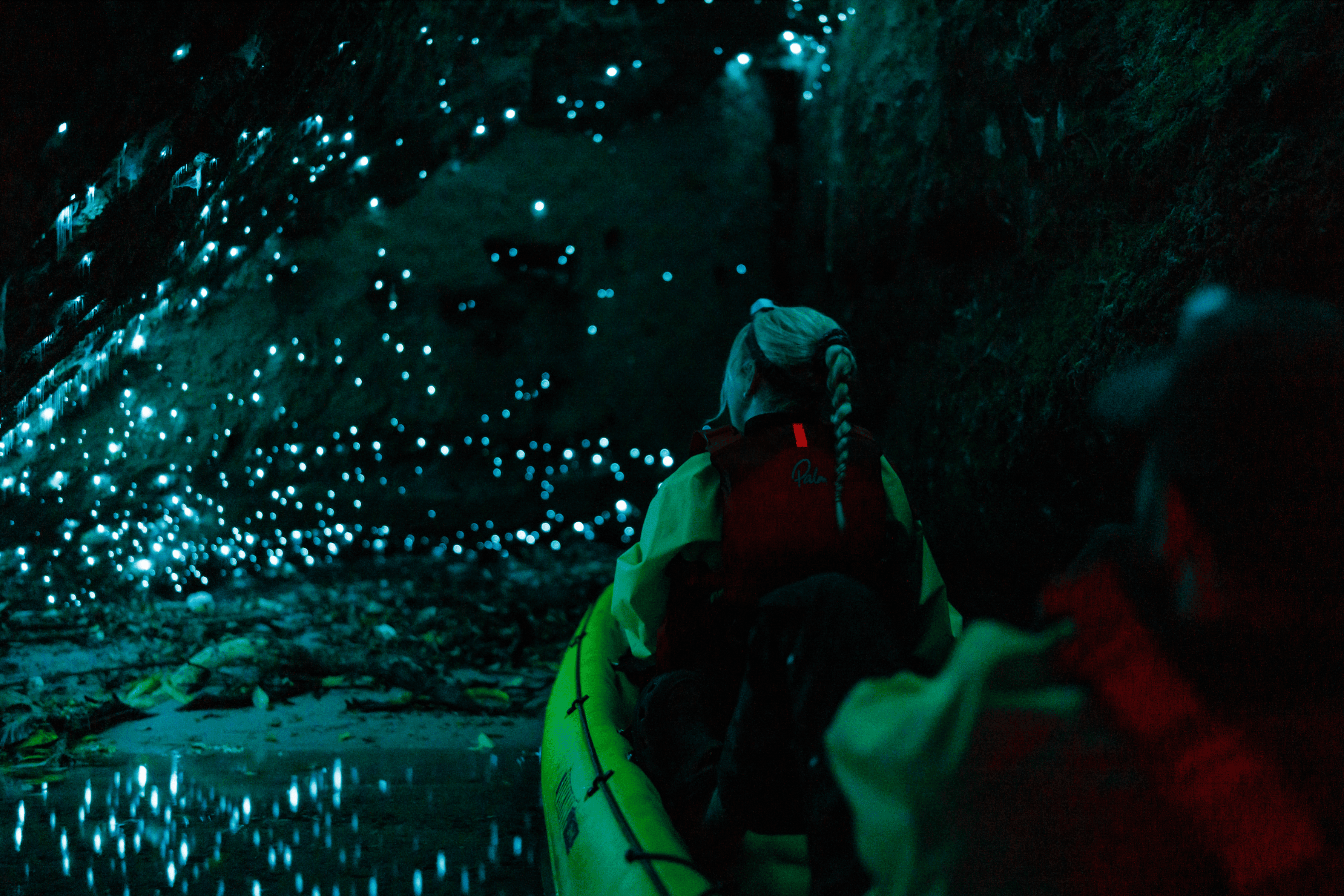 Kayaker entering a glow worm cave on a guided night kayak tour in Rotorua