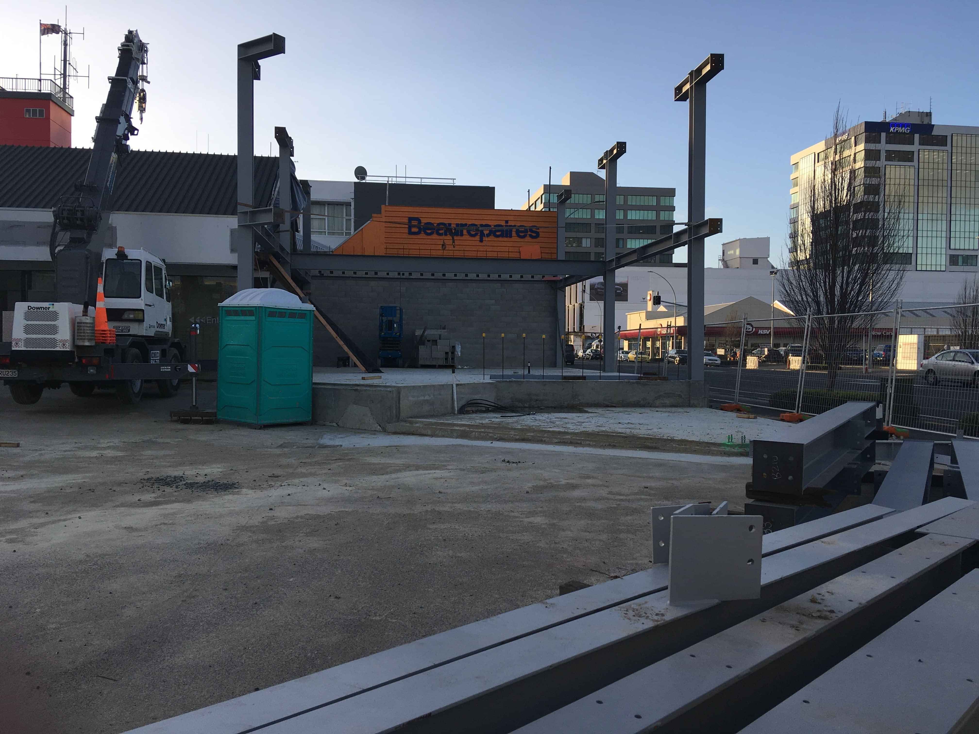 Modern waiting room with blue couch, round coffee table with plant, white vase, and painting on the wall.