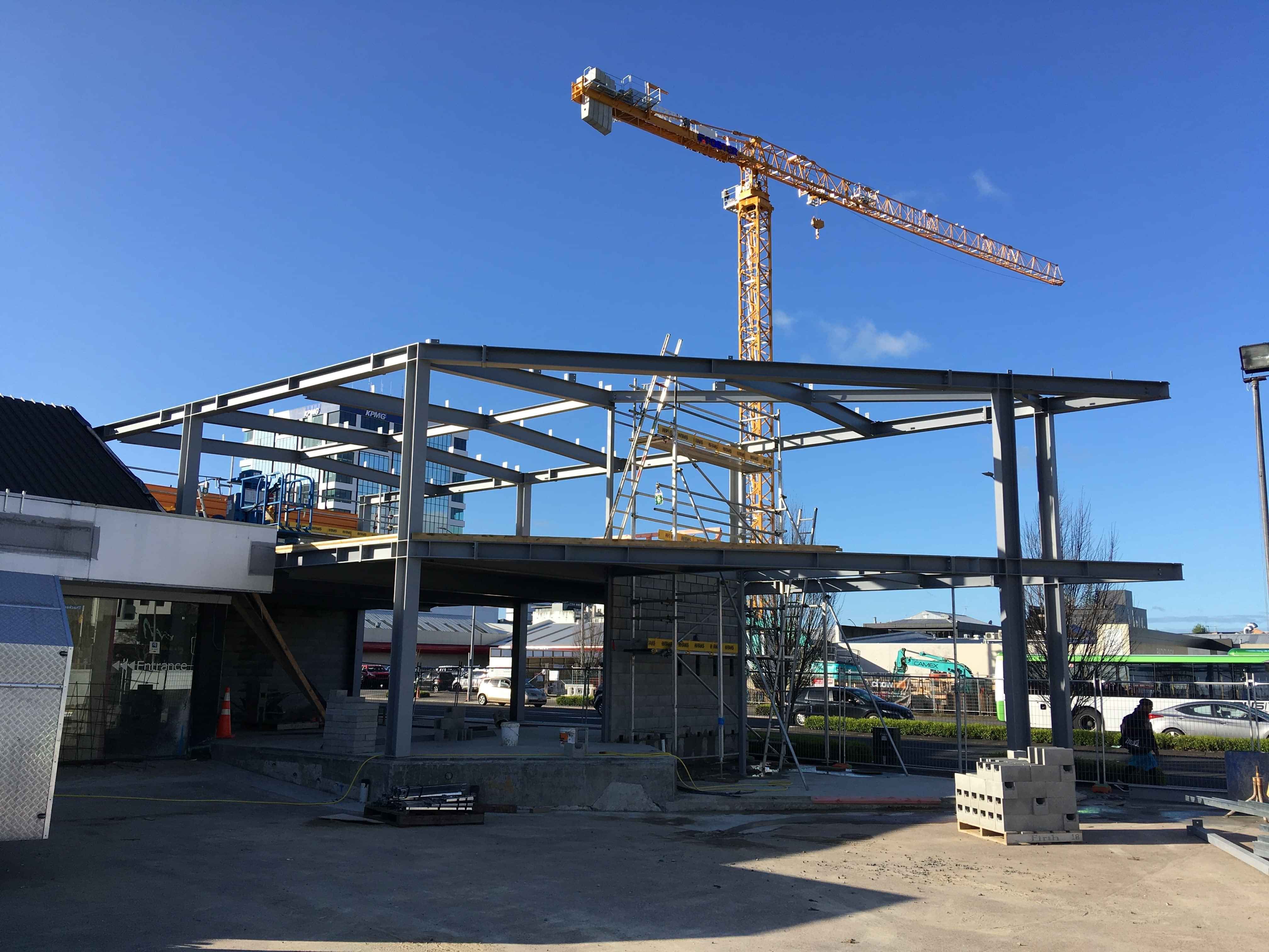 Modern waiting room with blue couch, round coffee table with plant, white vase, and painting on the wall.