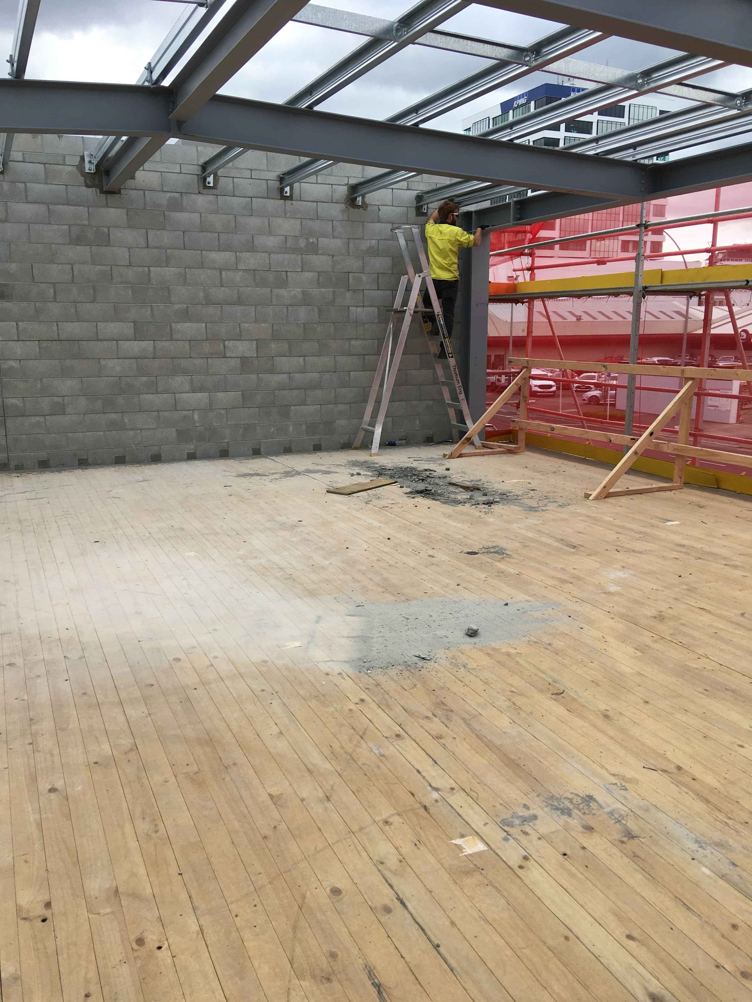 Modern waiting room with blue couch, round coffee table with plant, white vase, and painting on the wall.