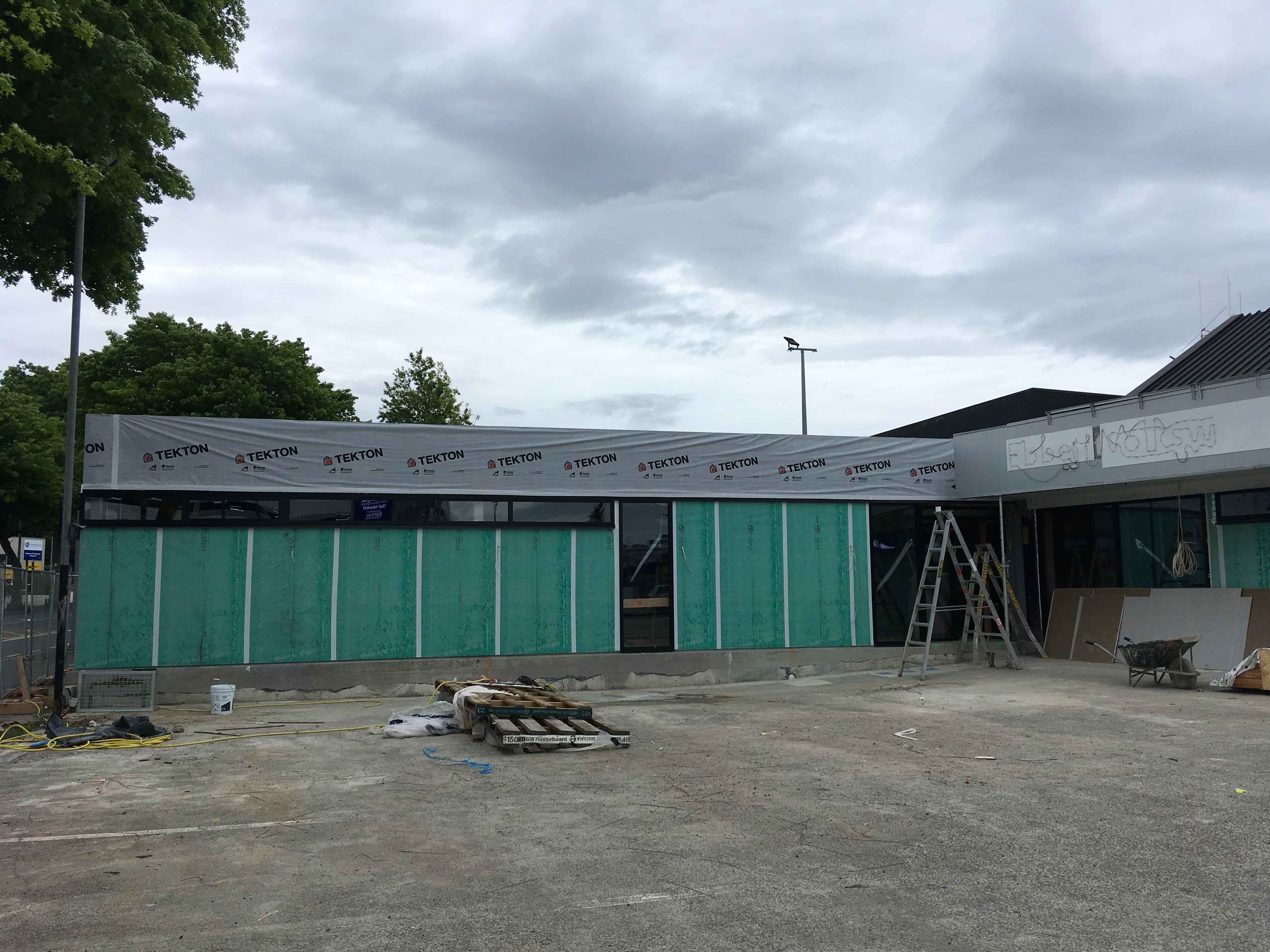 Modern waiting room with blue couch, round coffee table with plant, white vase, and painting on the wall.